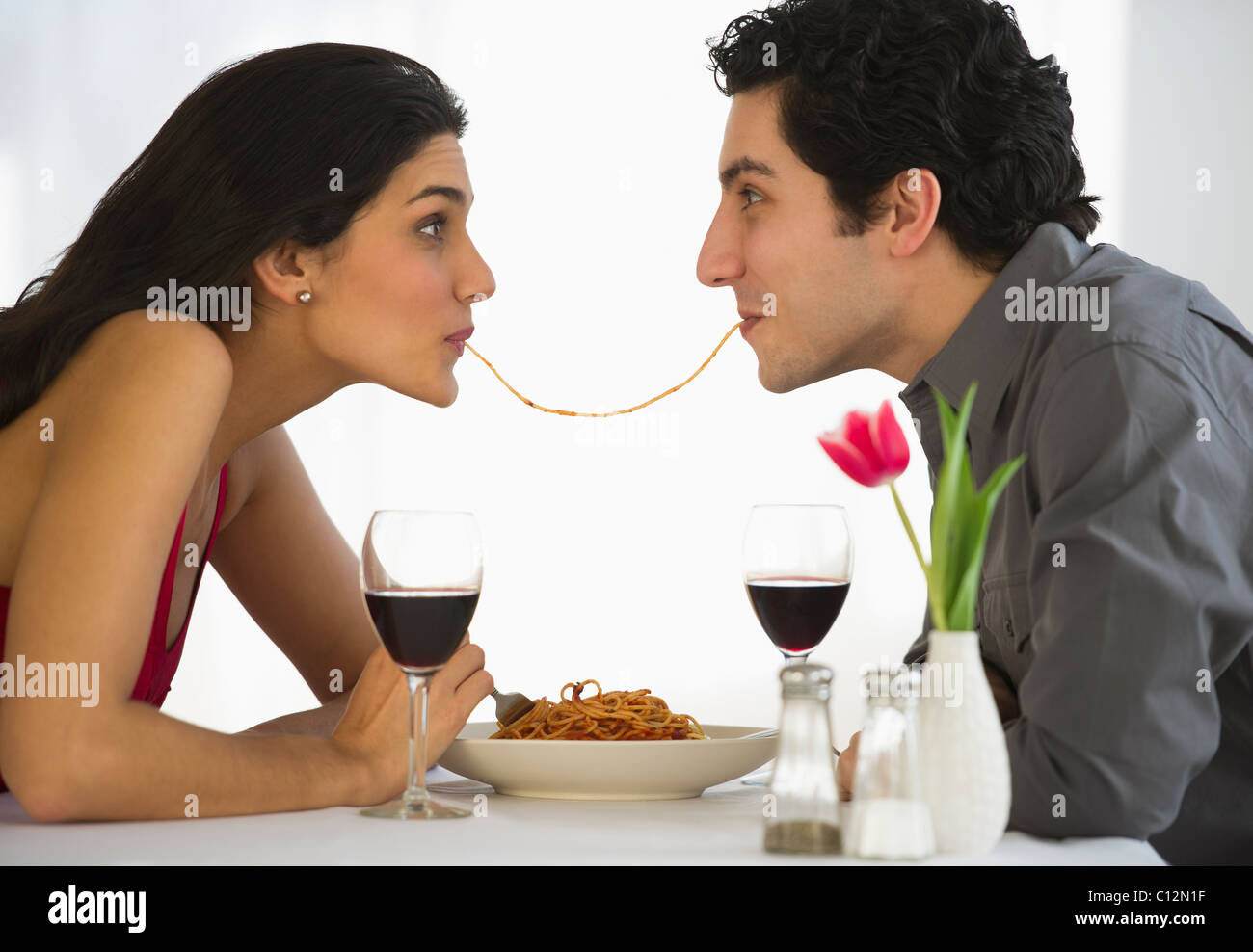 USA, New Jersey, Jersey City, Happy couple eating spaghetti together Stock Photo