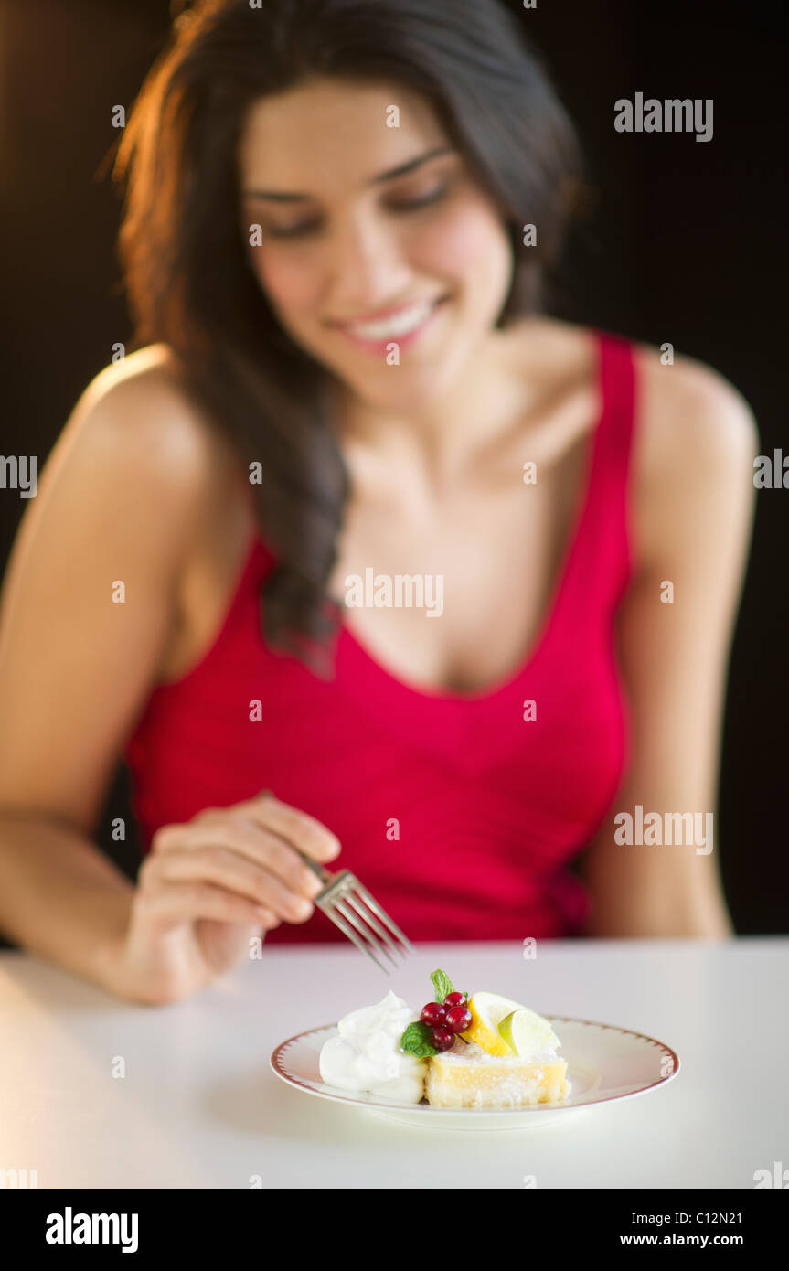 Happy woman eating dessert, studio shot Stock Photo