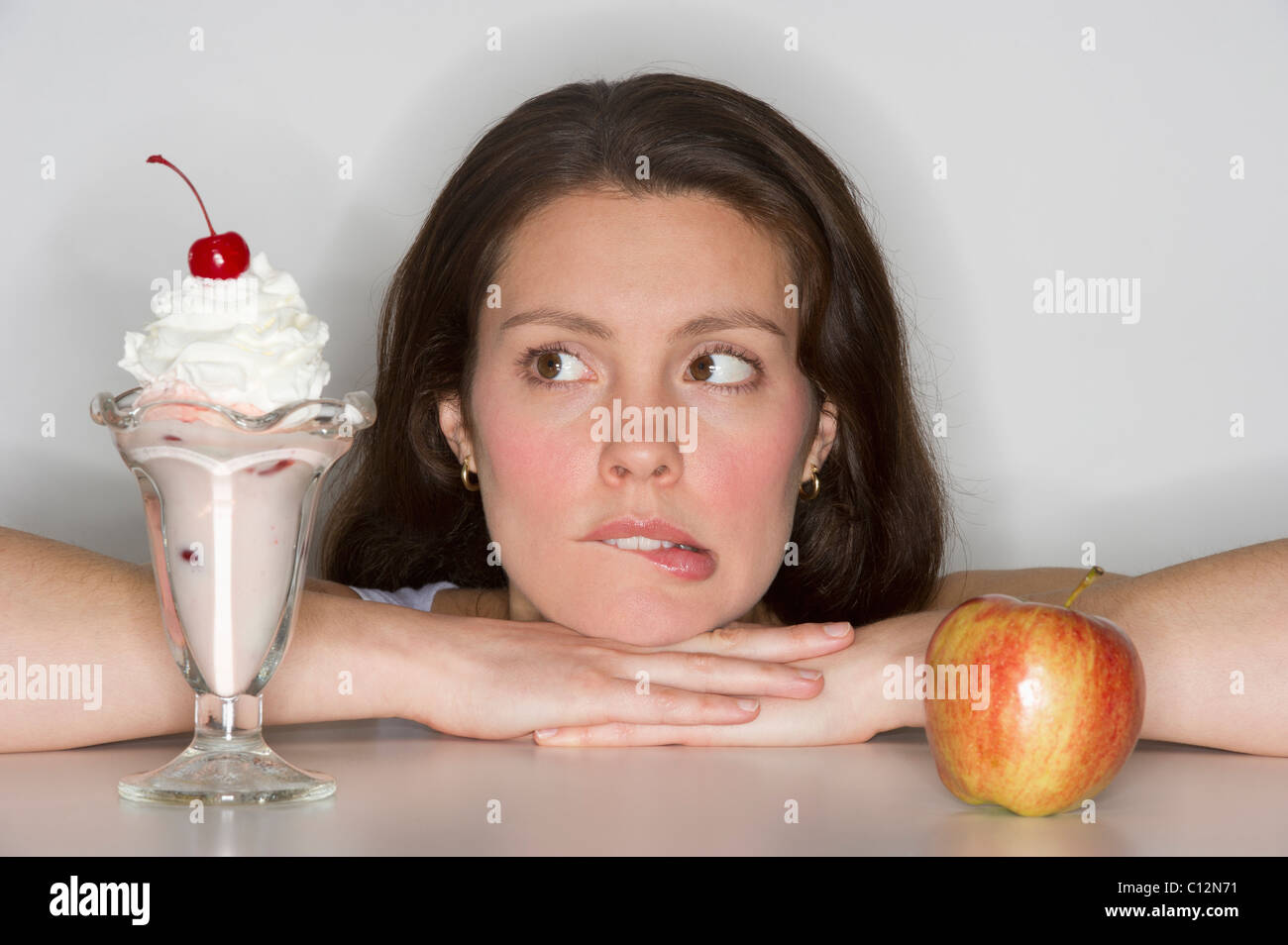 Woman choosing between ice cream and apple Stock Photo