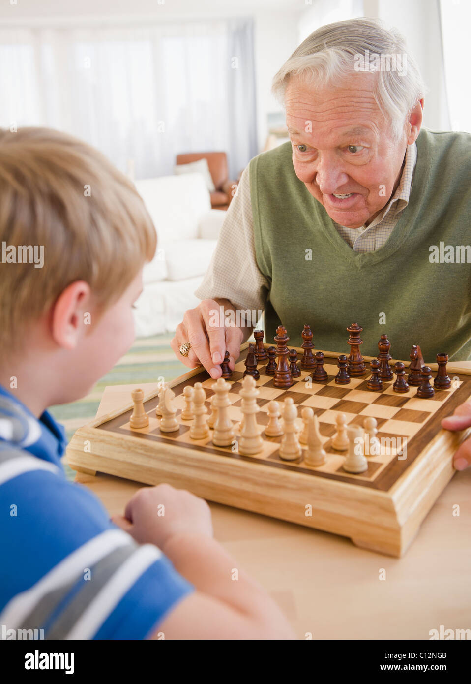 USA, New Jersey, Jersey City, grandfather and grandson (8-9) playing chess Stock Photo