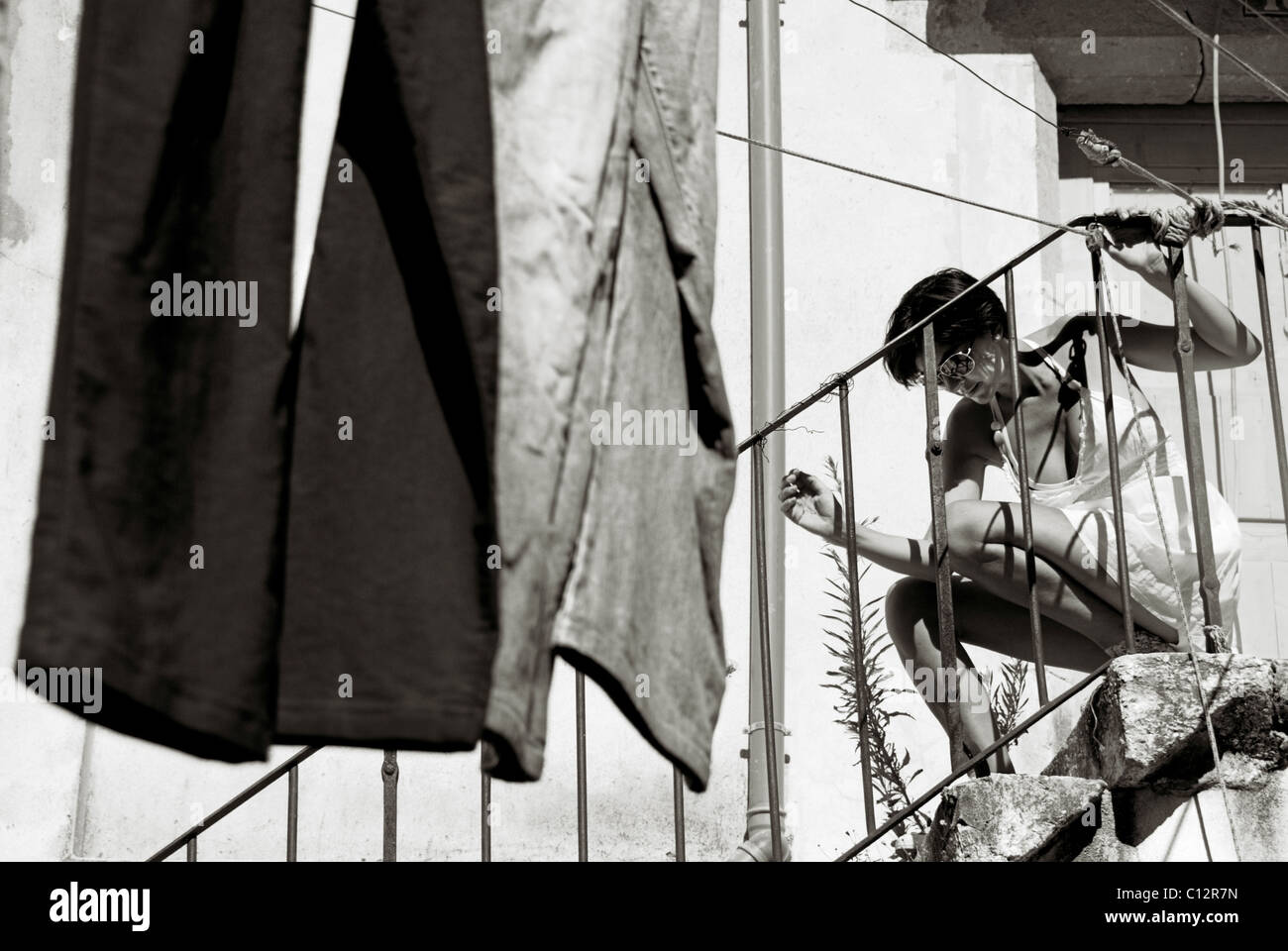 Woman with washing and courtyard steps, Lisbon, Portugal Stock Photo