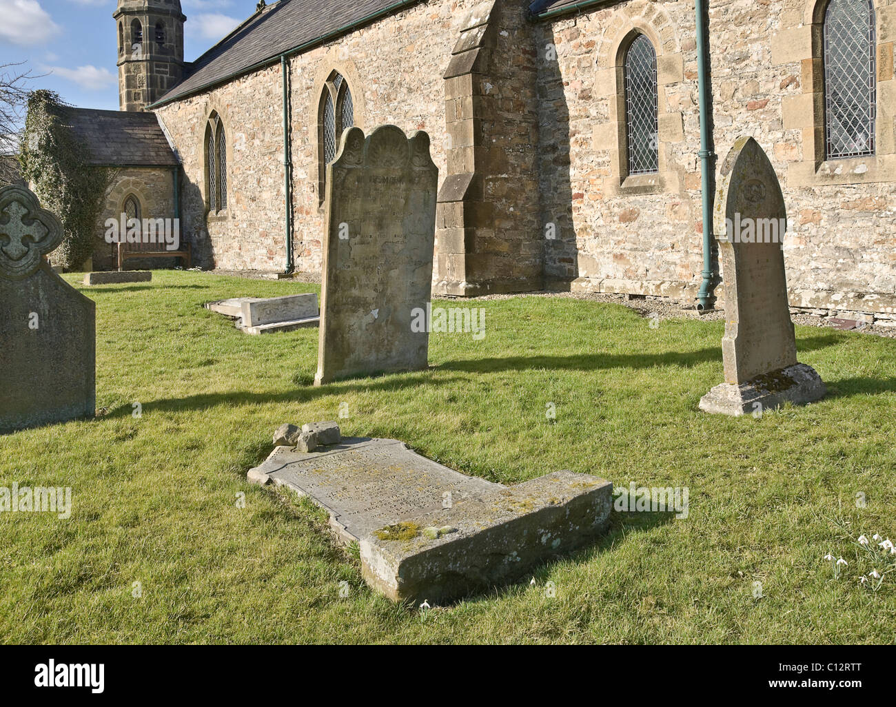 Grave stone flattened in the name of safety. Bellerby churchyard in North Yorkshire. Stock Photo