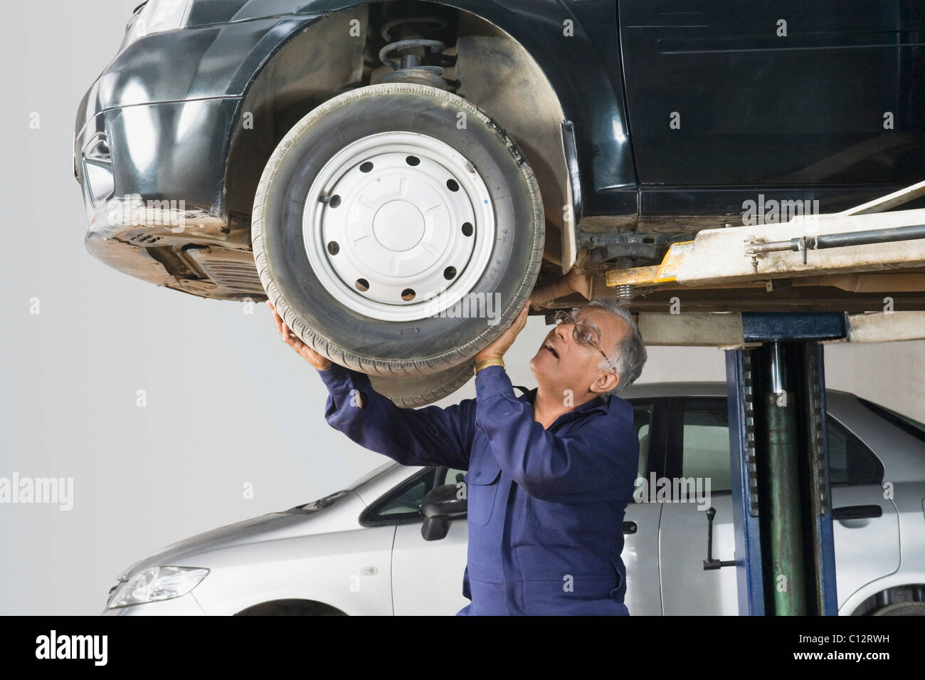 Mechaniker und sein Assistent untersuchen den Fahrzeugboden mit Blitzlicht. Auto  Auto Reparatur Service Center. Professioneller Service Stockfotografie -  Alamy