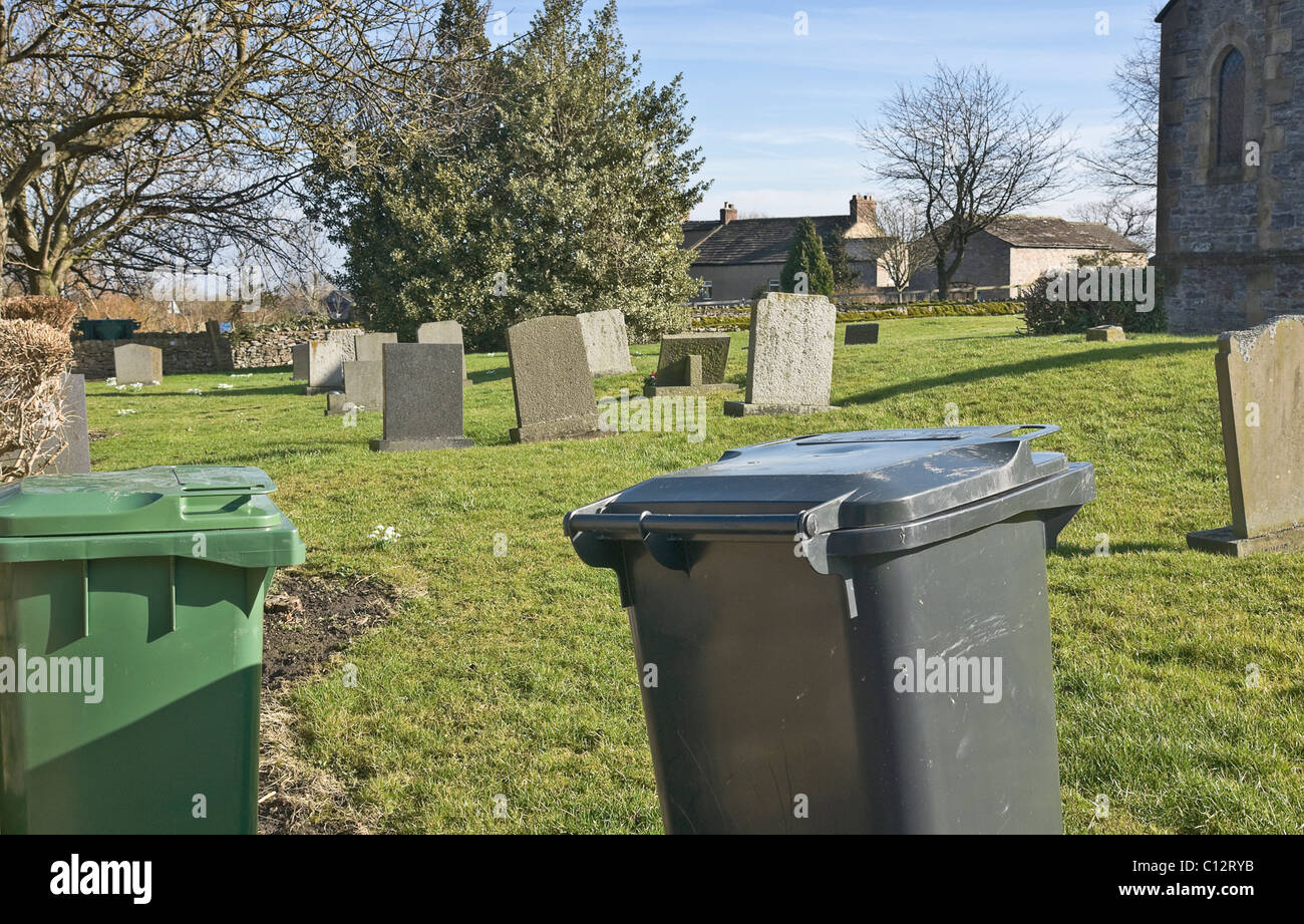 'Thou shalt recycle.'  Different coloured bins in the corner of a churchyard. Stock Photo