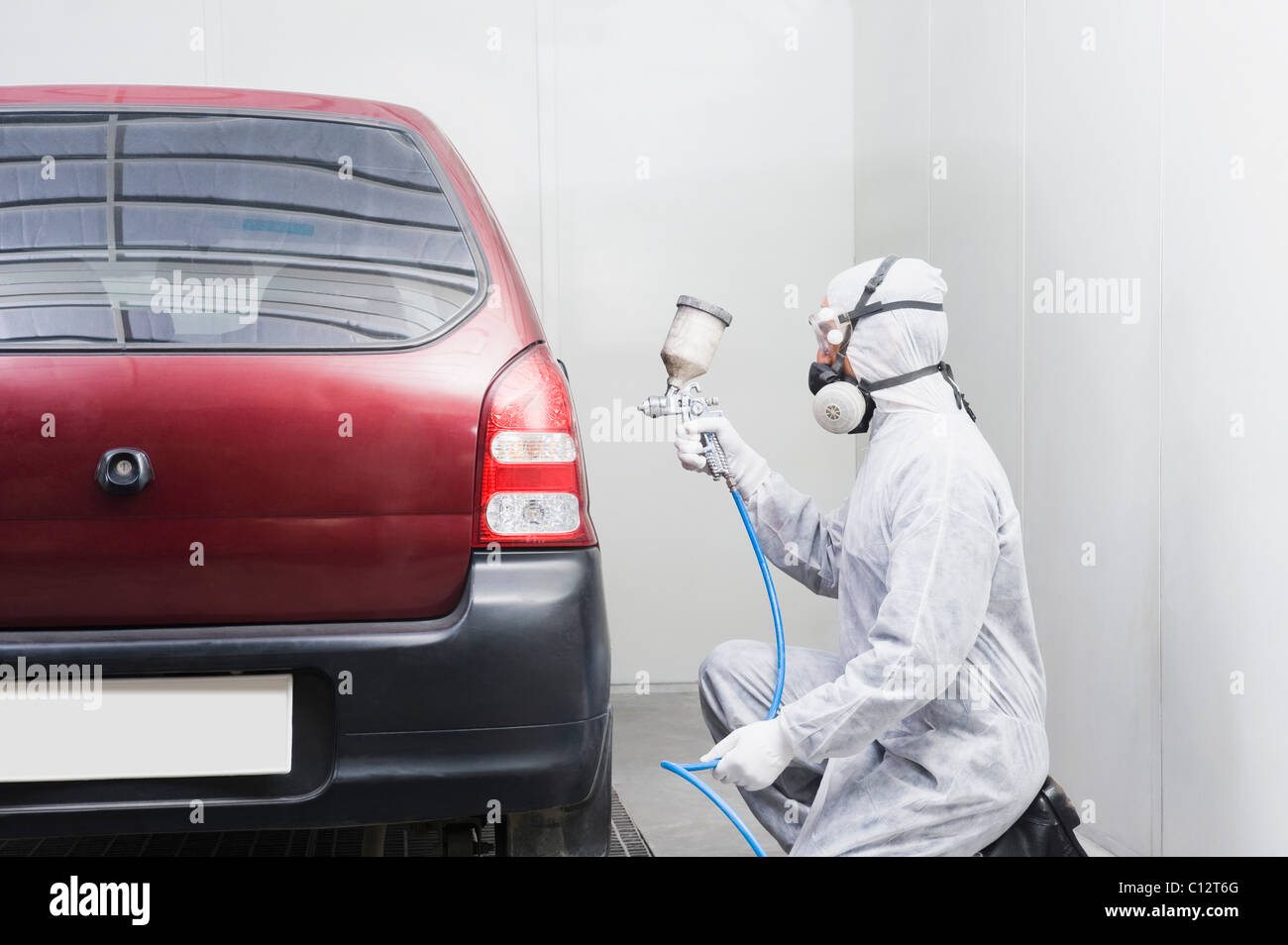 Auto mechanic painting a car in a garage Stock Photo Alamy