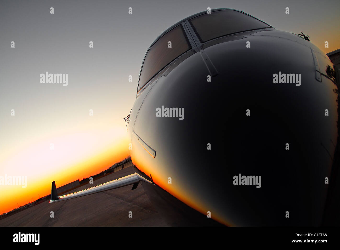 Private jet on runway at sunset Stock Photo Alamy