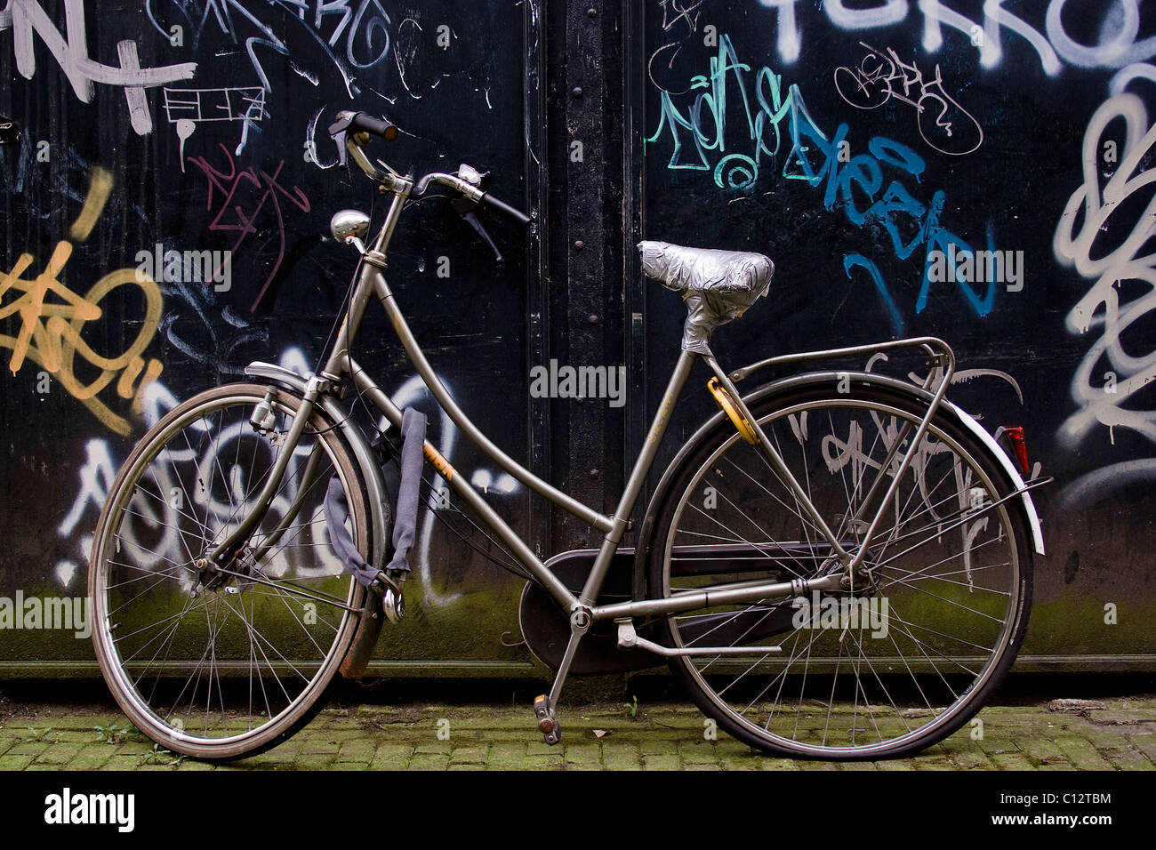 Bicycle parked by graffiti wall Stock Photo