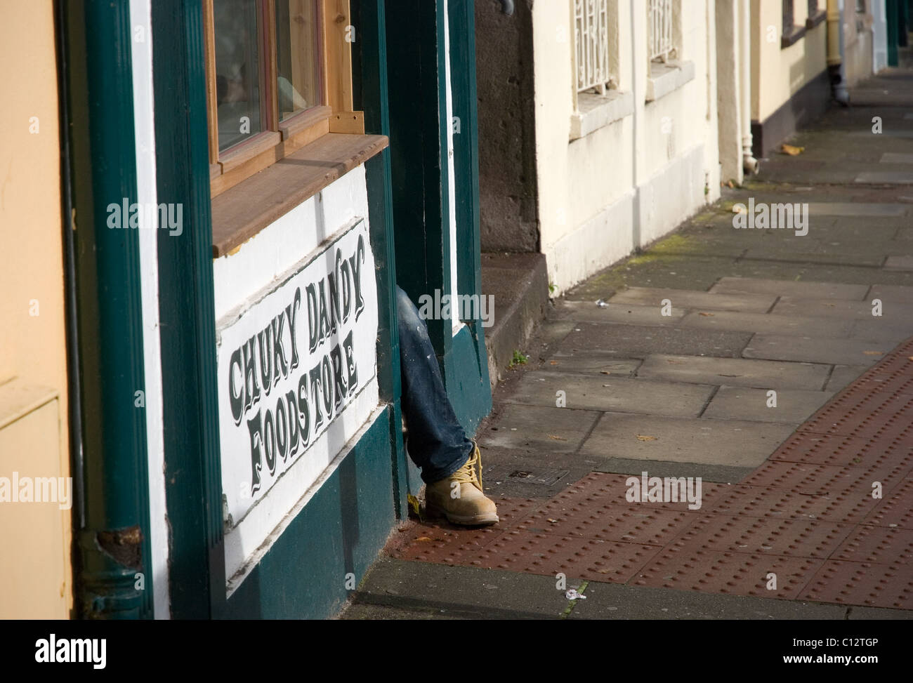 Man sitting on shop step, Cork, Ireland Stock Photo
