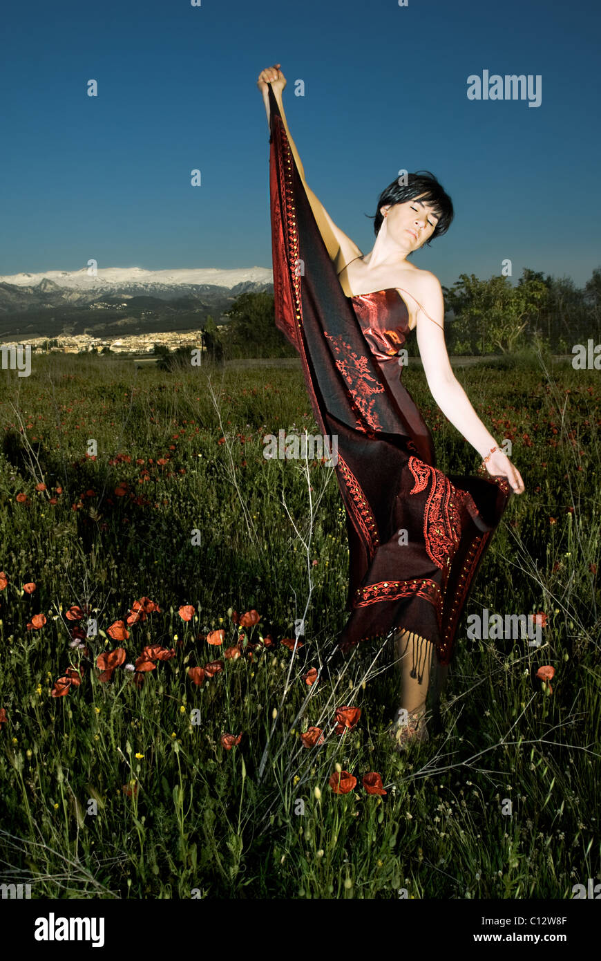 Woman holds shawl in field of wildflowers, Granada, Andalusia Stock Photo