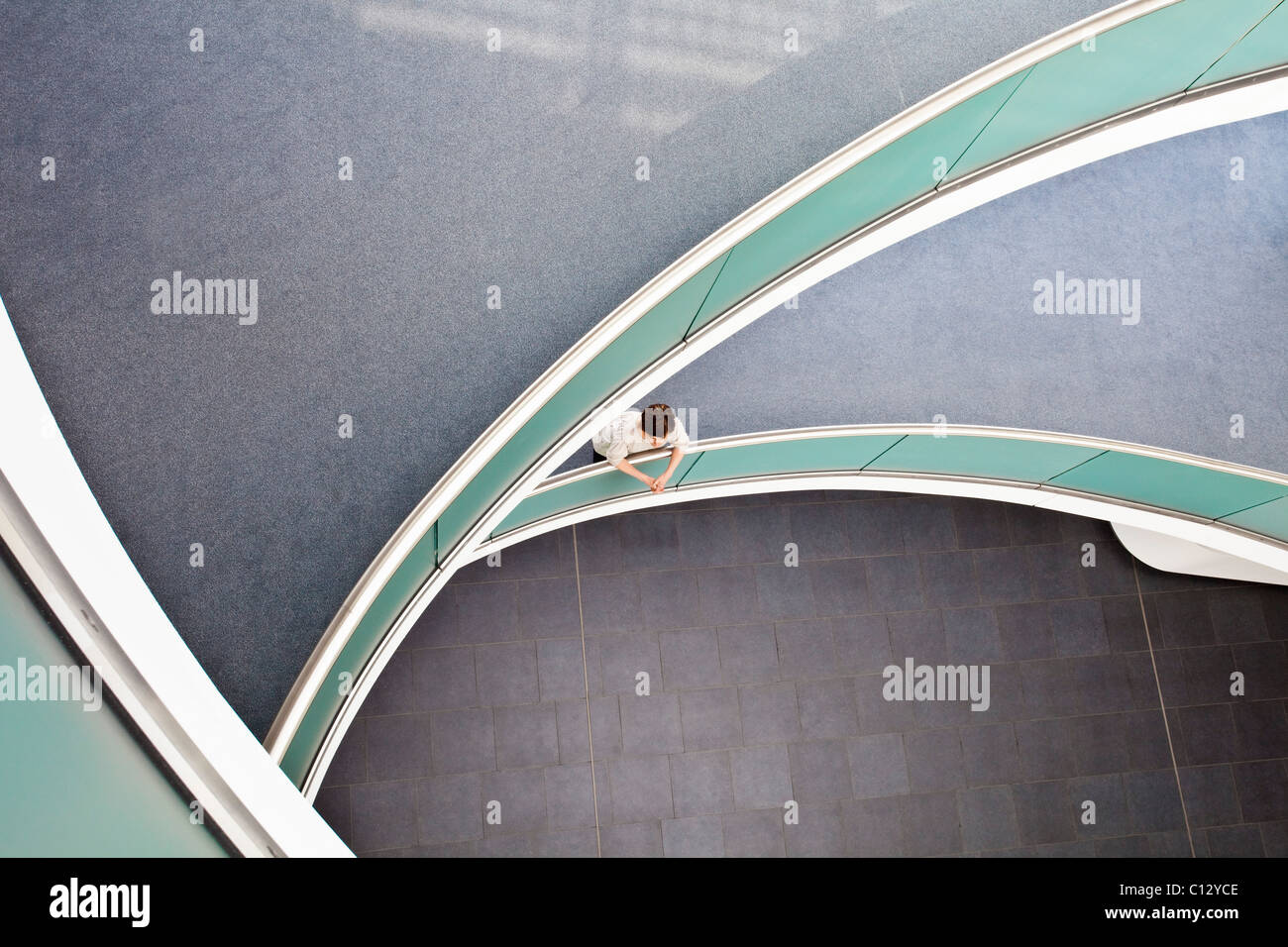 high angle view of woman standing in staircase of office building Stock Photo