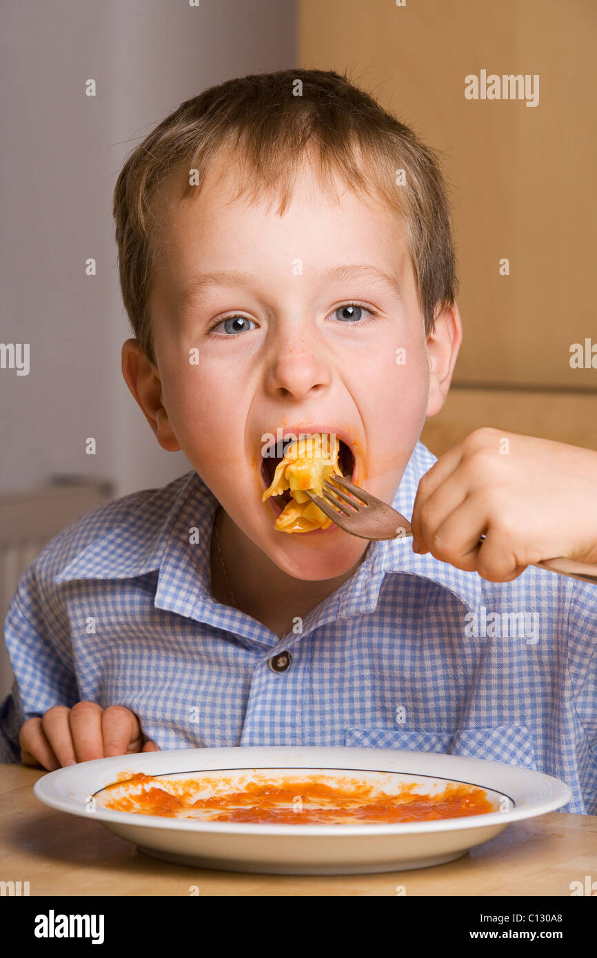 portrait of young boy eating pasta Stock Photo