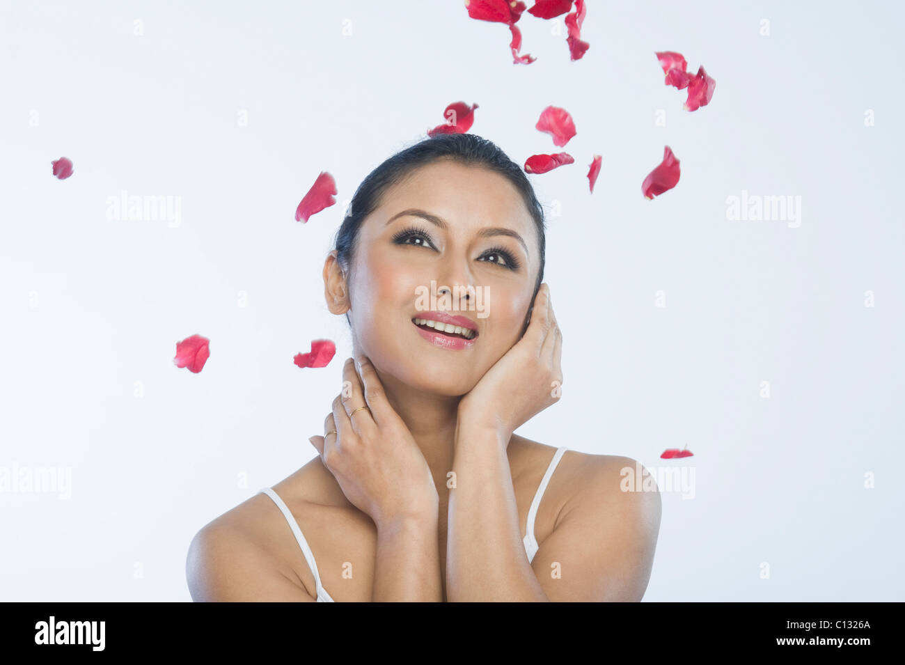 Rose petals falling on a woman Stock Photo
