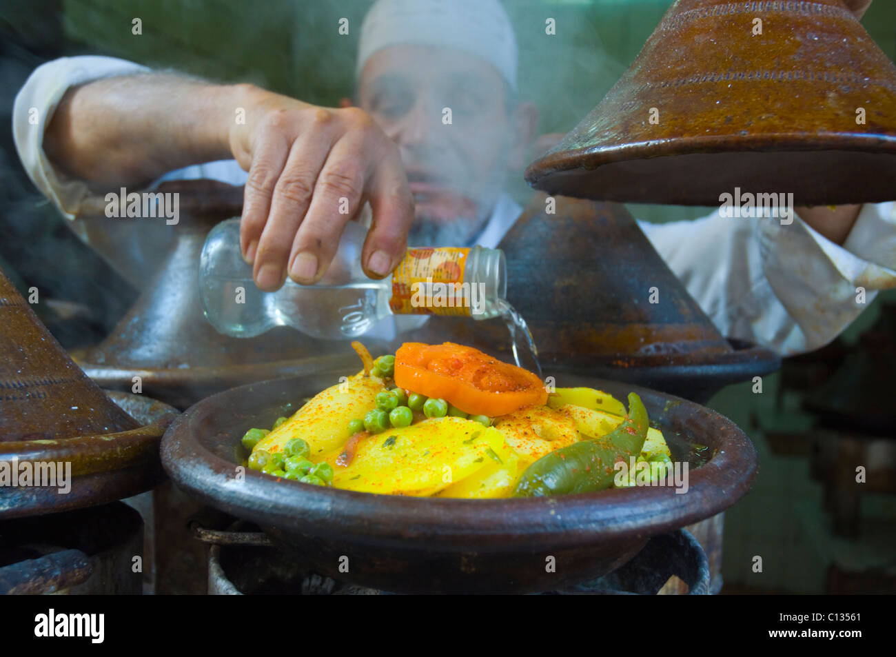 Man adding water into tagine pot Medina old quarter Casablanca central