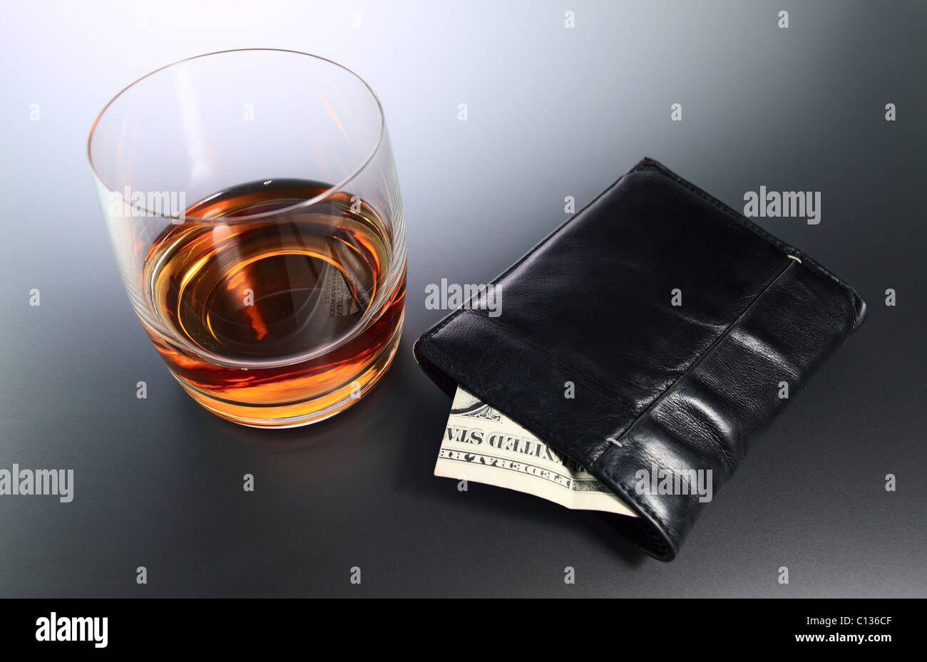 Whisky and money in black purse. Stock Photo