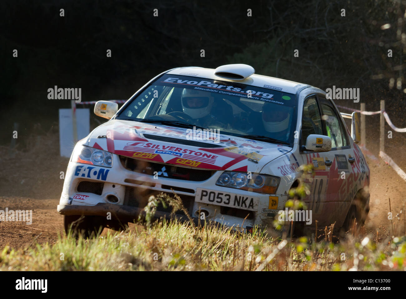 A rally car almost going off the road as it exits a bend. Stock Photo