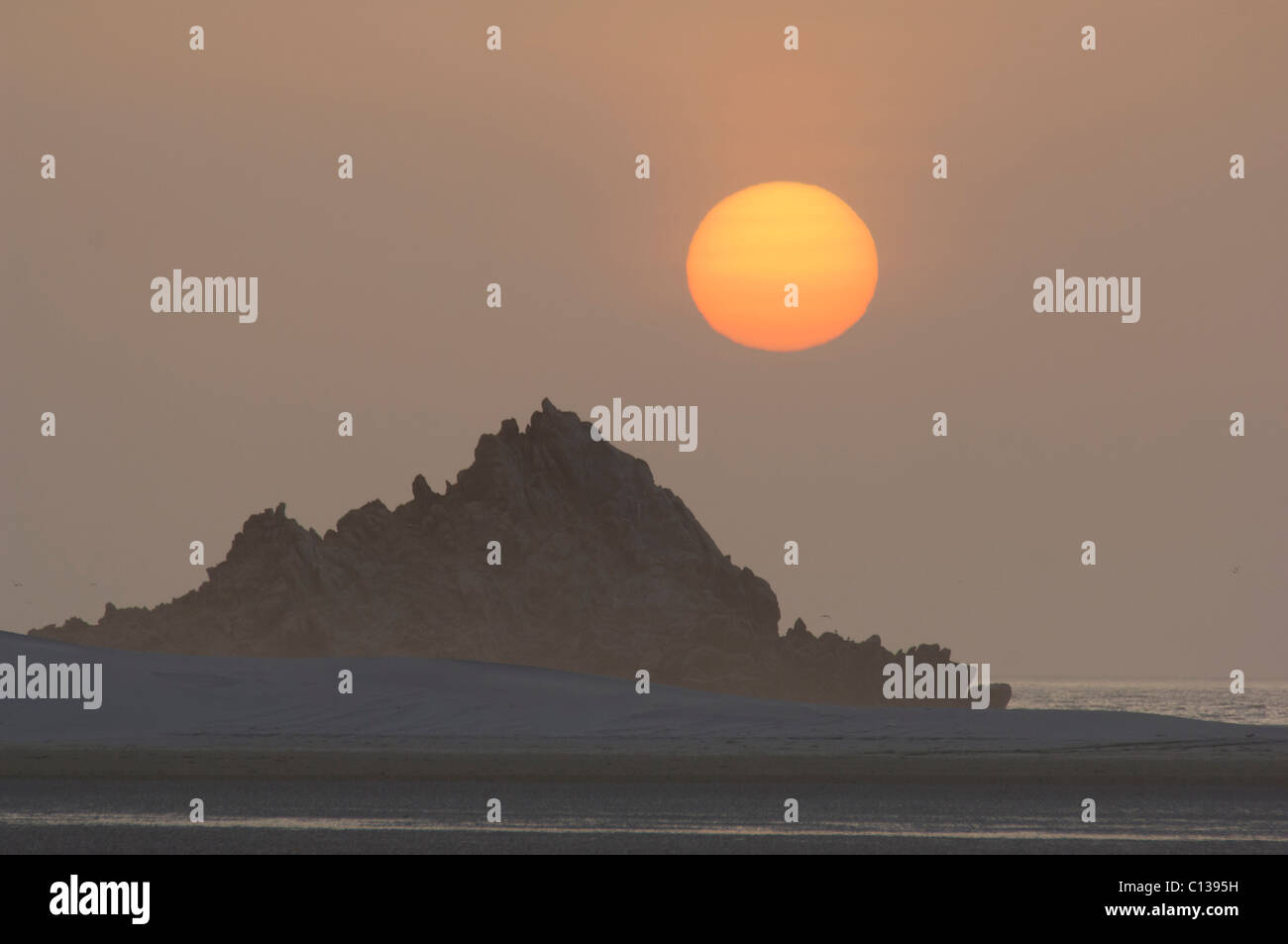 Sun setting behind a rock formation at Detwah lagoon near Qulansiyah, Socotra, Yemen Stock Photo