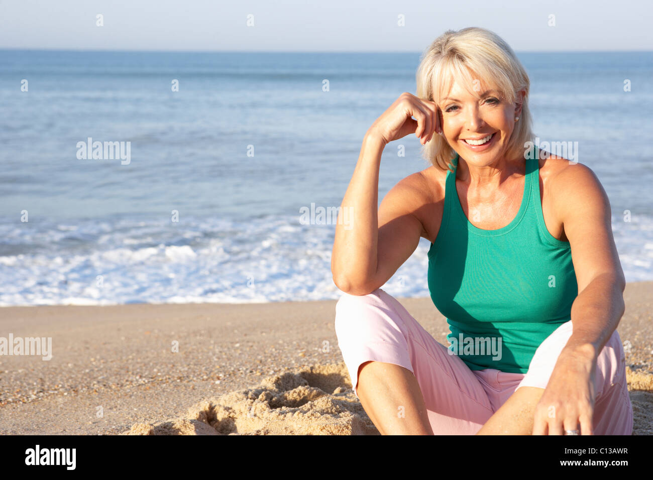 Senior woman sitting on beach relaxing Stock Photo - Alamy
