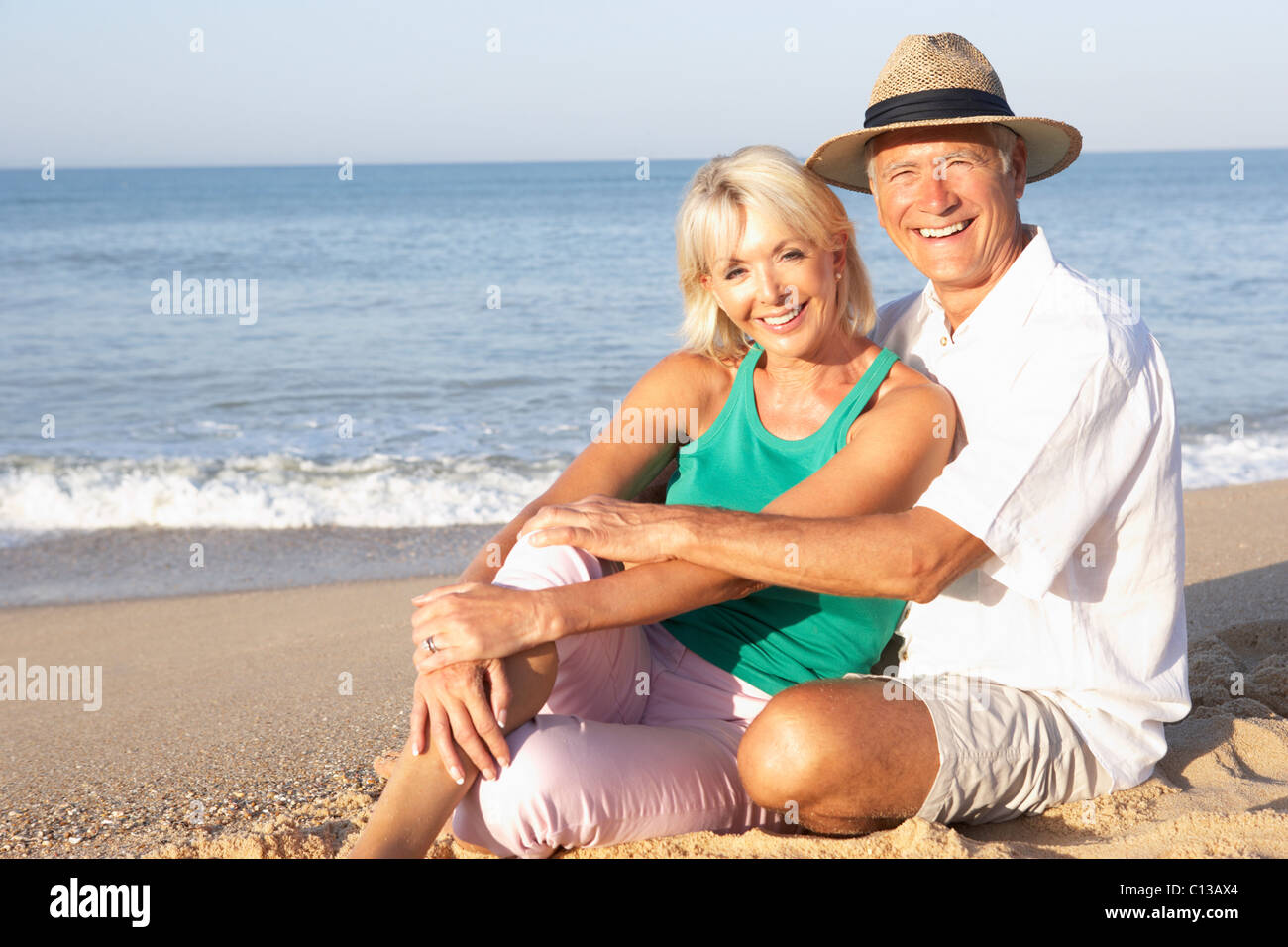 Senior couple sitting on beach relaxing Stock Photo - Alamy