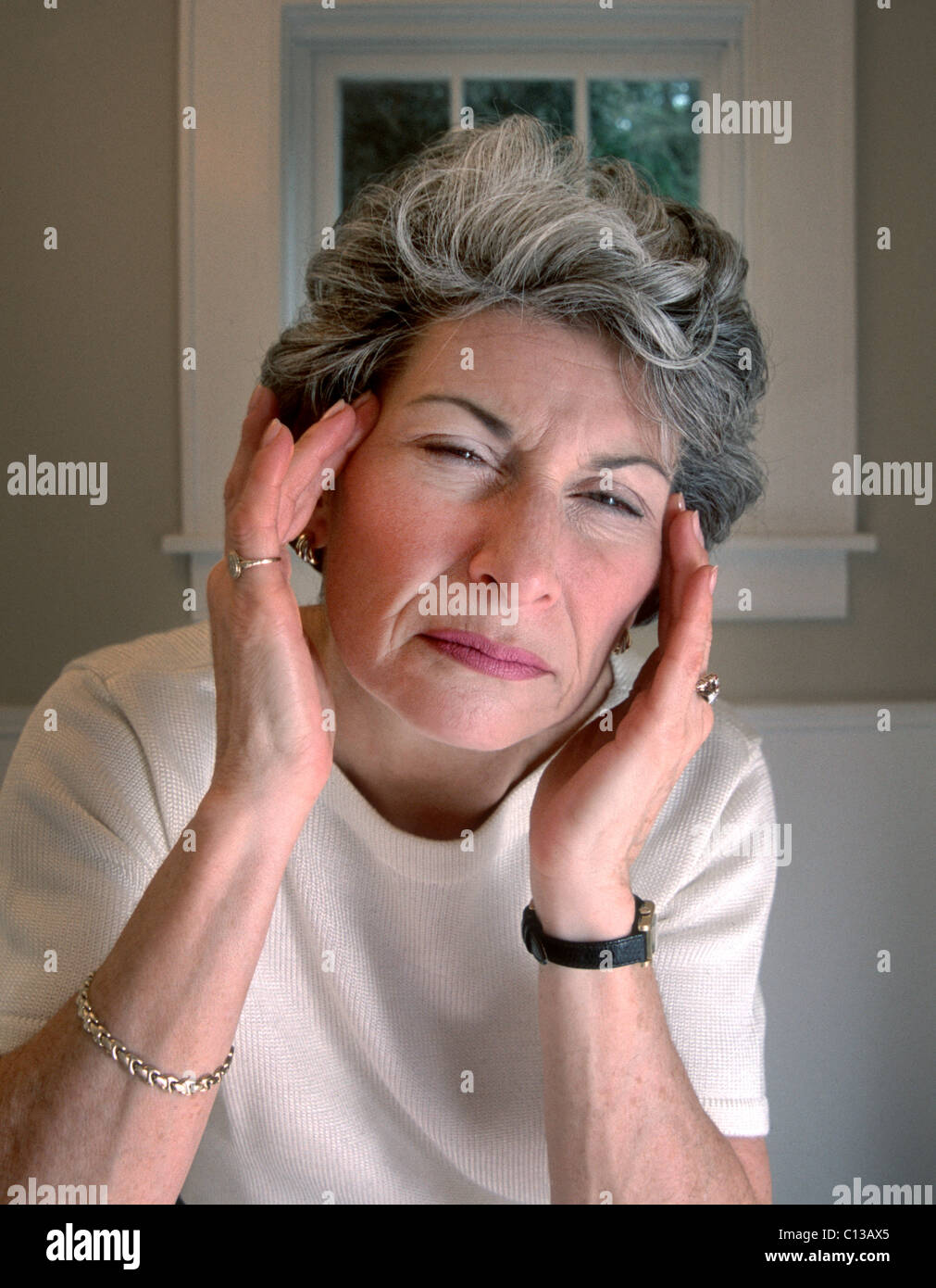 Older Caucasian woman experience headache pain. Stock Photo