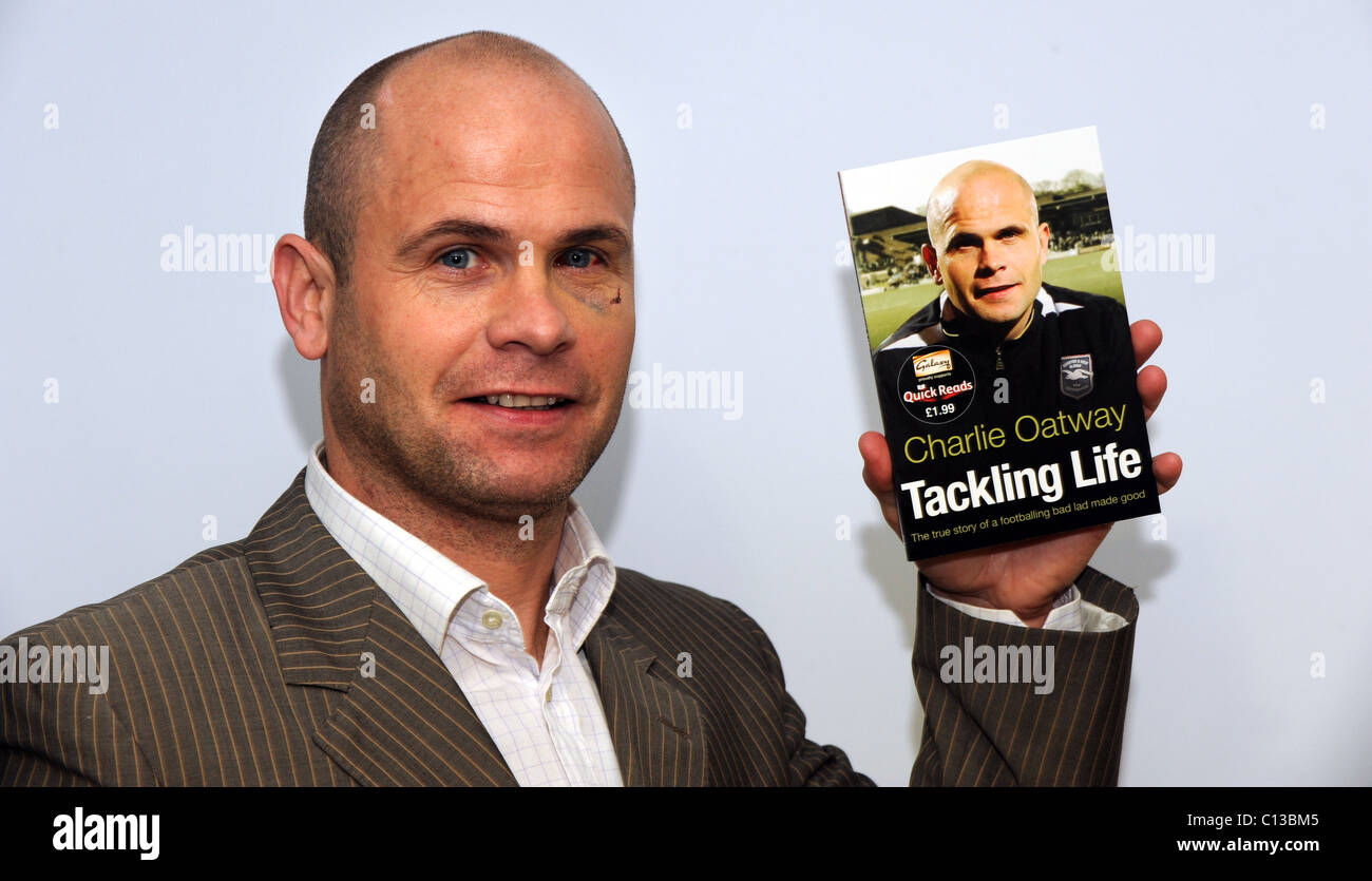 Former footballer and now Brighton and Hove Albion first team coach Charlie Oatway  holding his new autobiography Tackling Life Stock Photo