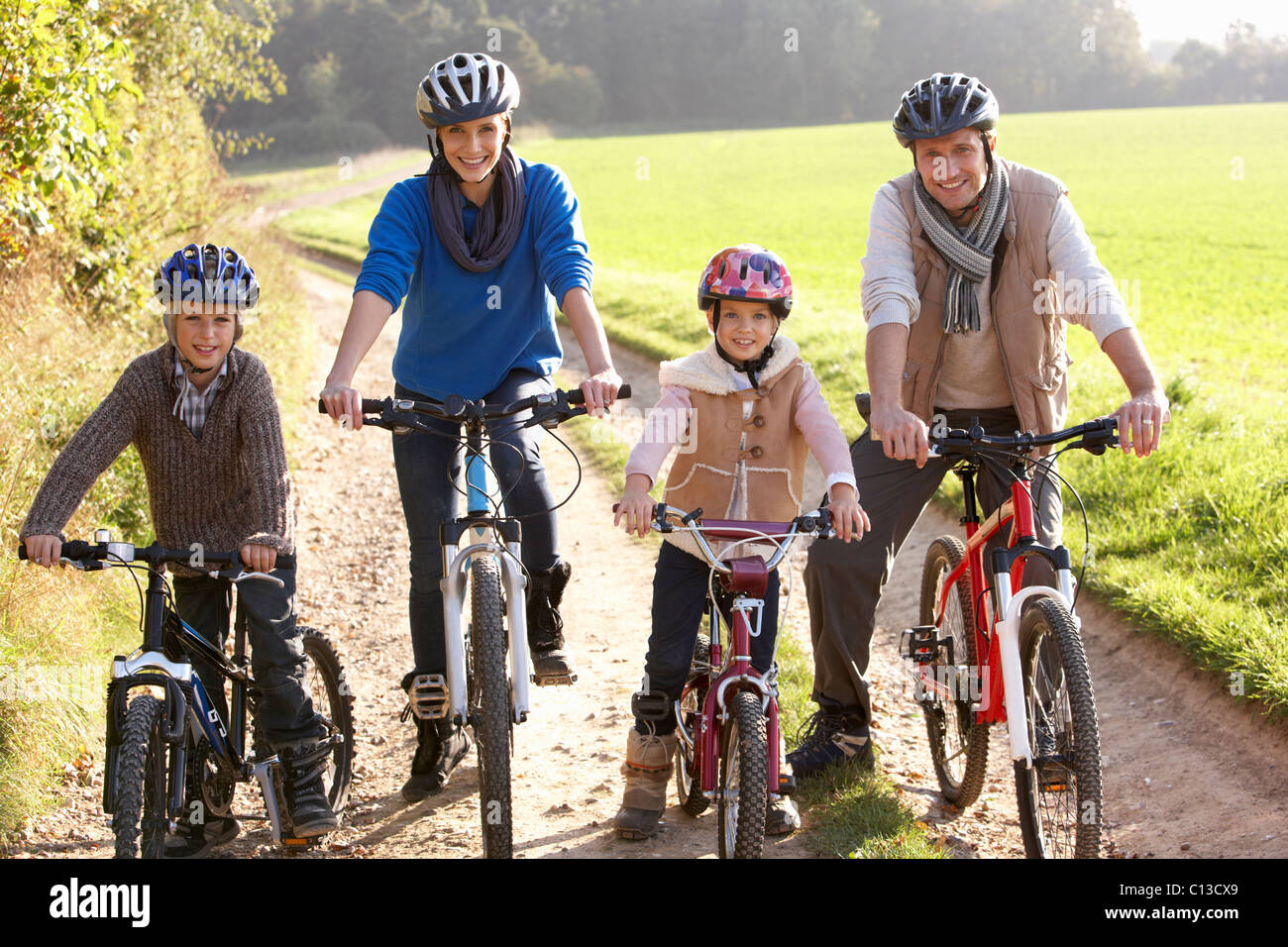 Young family pose with  bikes in park Stock Photo