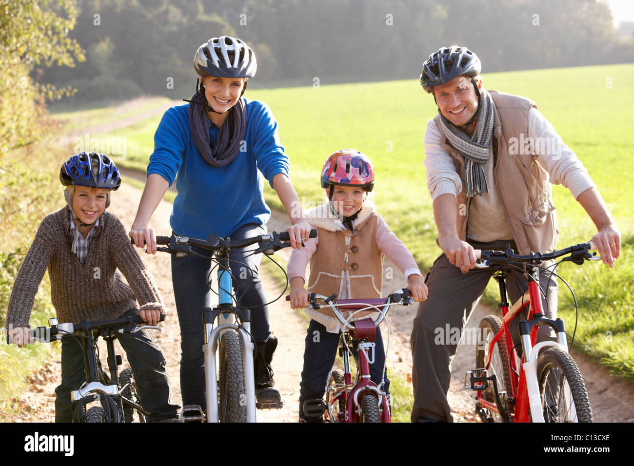 Young family pose with bikes in park Stock Photo - Alamy