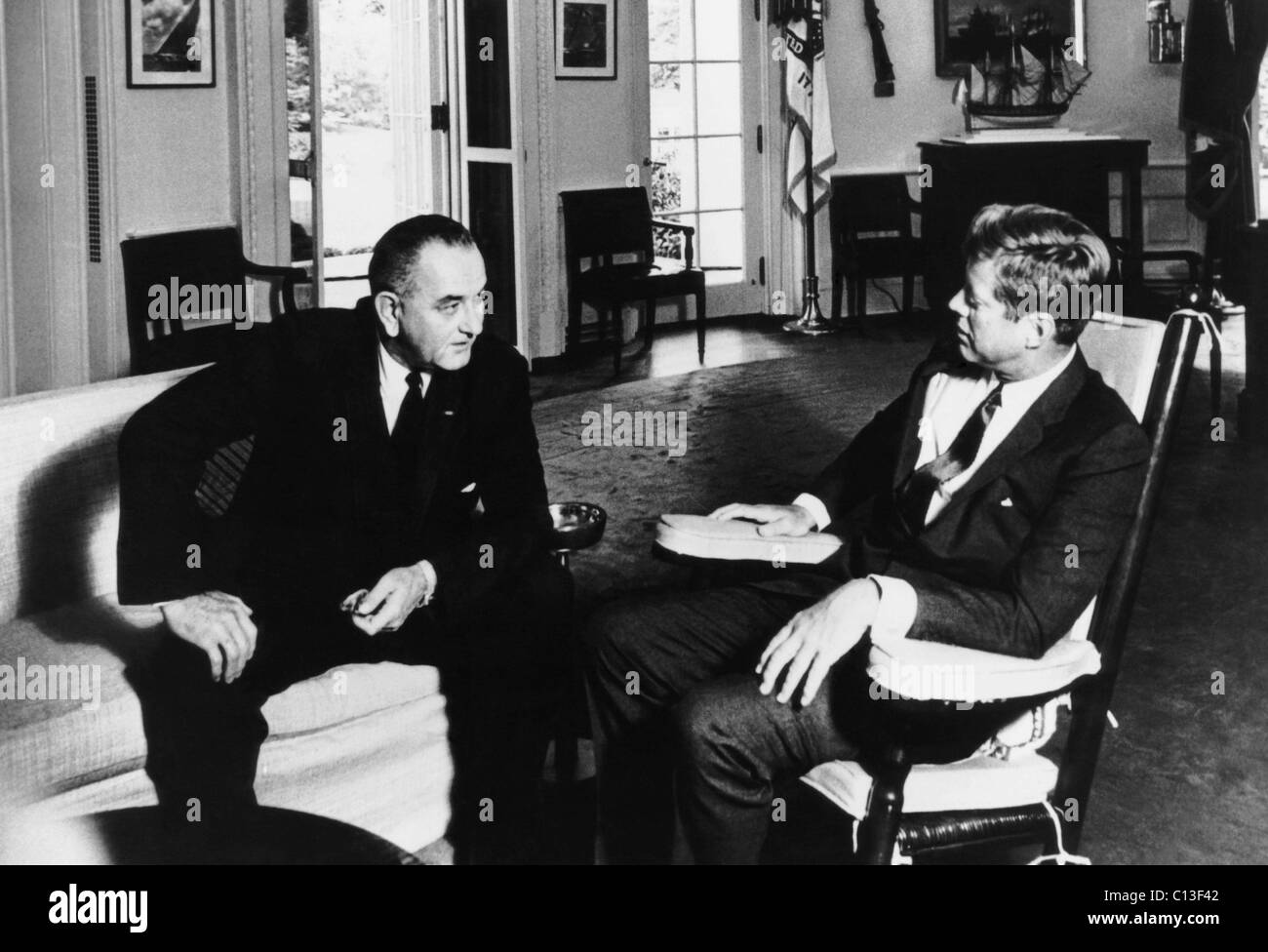 From left, Vice President Lyndon Johnson, President John F. Kennedy, in the Oval Office, 1963 Stock Photo