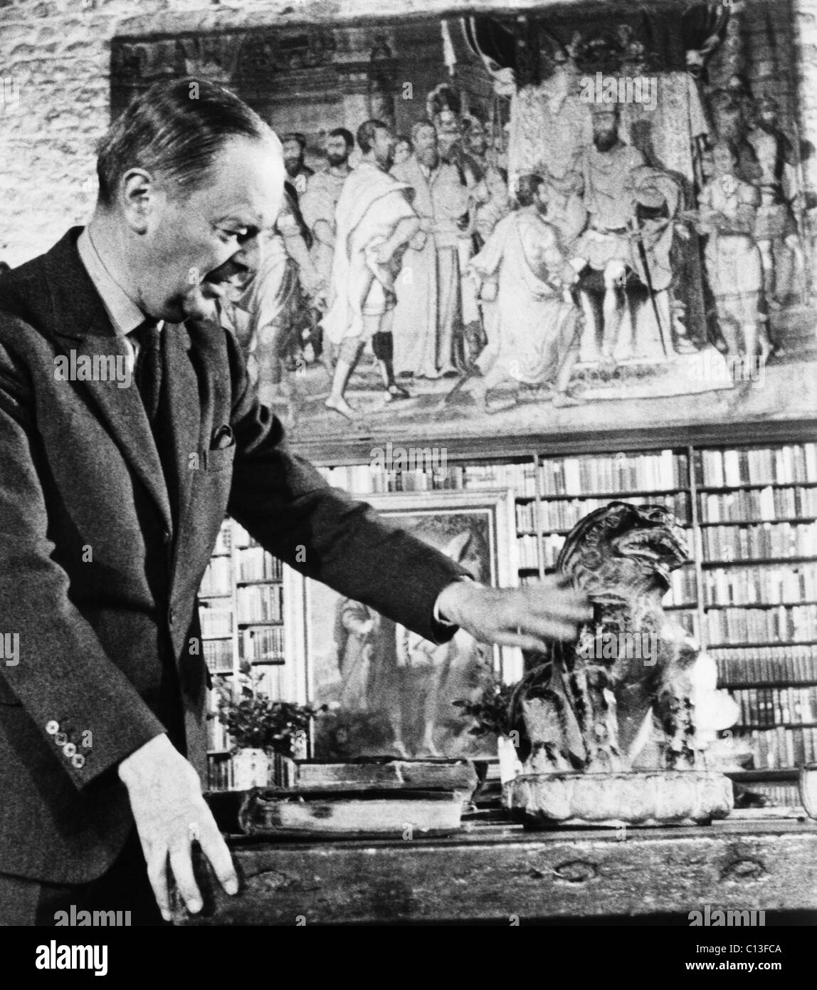 Kenneth Clark (1903-1983), English author and art historian, presenting CIVILISATION, here he is examining a Ming Lion in the library of his home, Saltwood Castle in Kent, England, circa 1970. Stock Photo