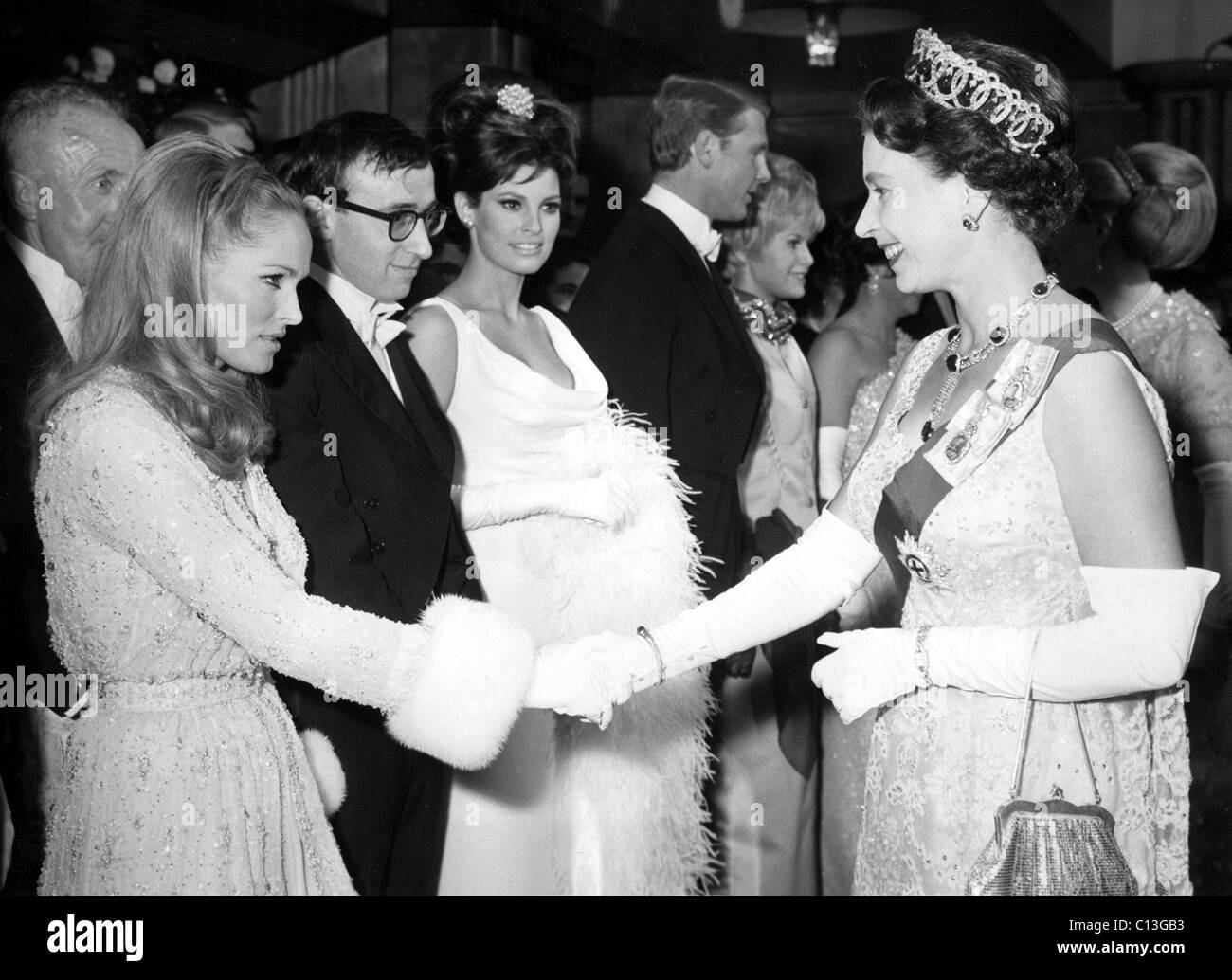 QUEEN ELIZABETH II shakes hands w/Ursula Andress after Woody Allen, Raquel Welch, James Fox & Suzannah Leigh after BORN FREE, 3-15-66. Stock Photo