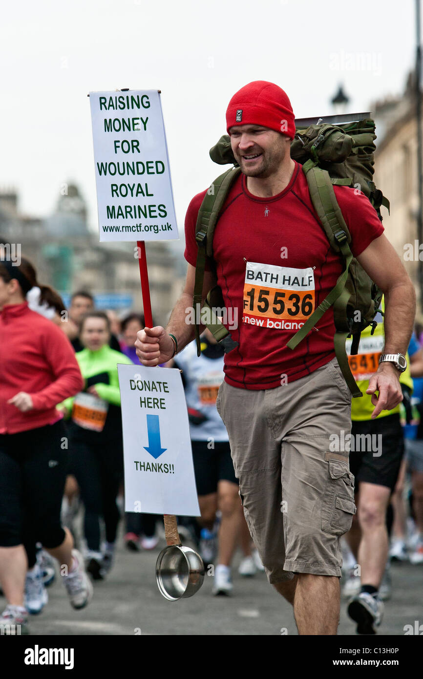 A runner fund raising for an armed forces charity runs down Great Pulteney Street at the start of The 30th Bath Half Marathon. Stock Photo