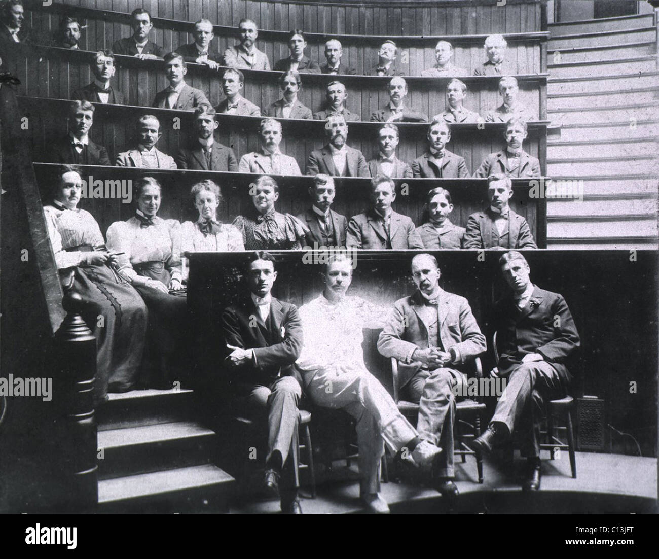 Professors Harvey Cushing, Howard Kelly, Sir William Osler, and William S. Thayer (front row) sit with the graduating class of Johns Hopkins Medical School in the surgical amphitheater. Ca. 1900. Stock Photo
