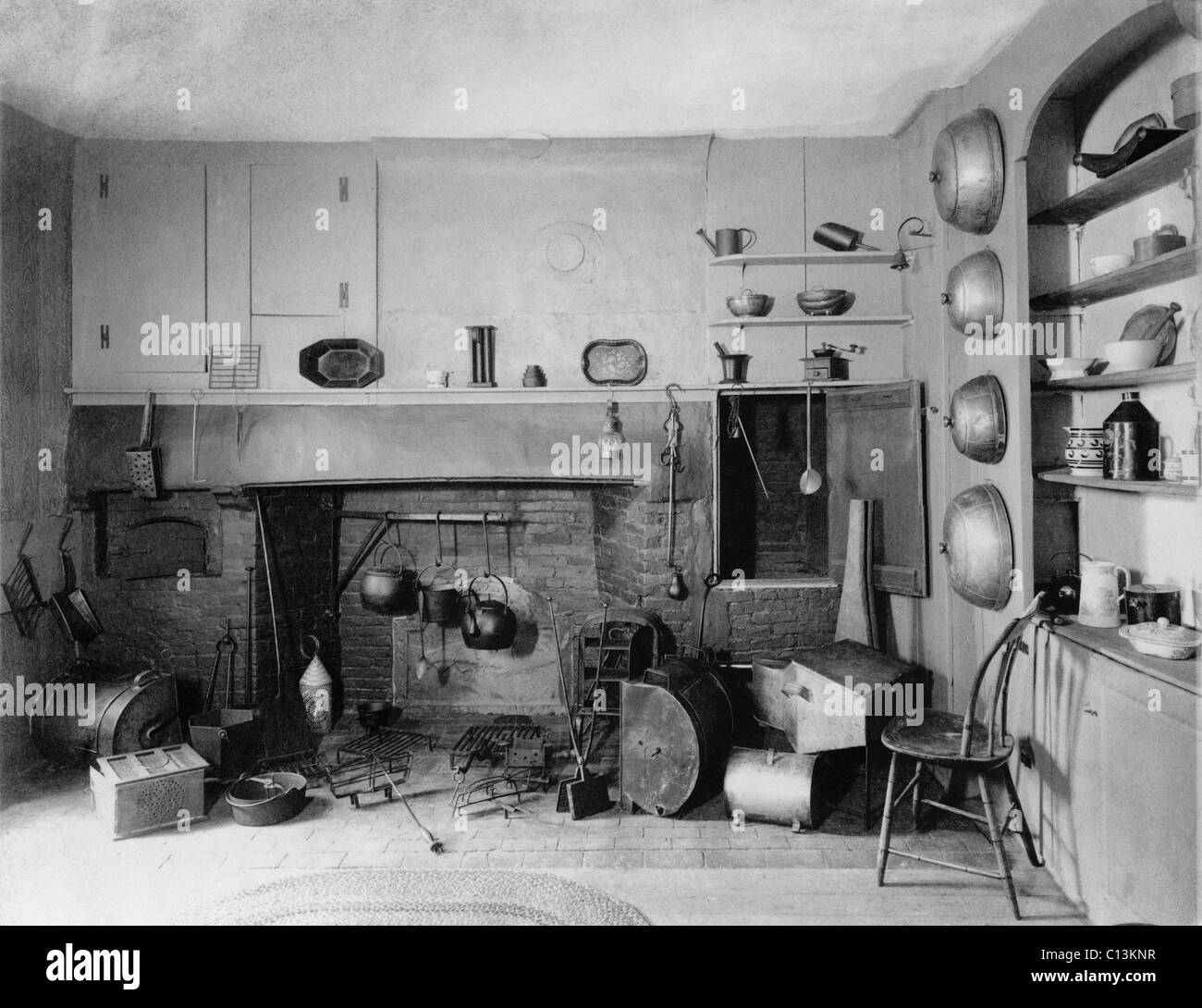 American Colonial era fireplace with the utensils and tools for cooking on an open fire. Stock Photo