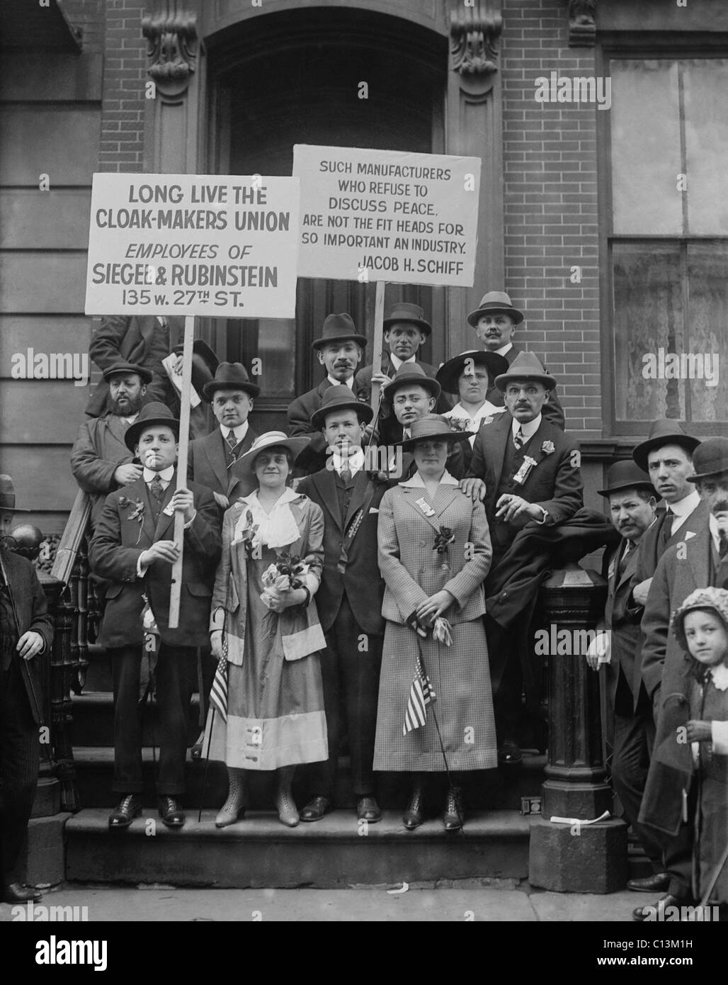 On May Day, striking cloak makers display a sign reading, SUCH MANUFACTURERS WHO REFUSE TO DISCUSS PEACE ARE NOT FIT HEADS FOR SO IMPORTANT AN INDUSTRY. New York City, May 1, 1916. Stock Photo