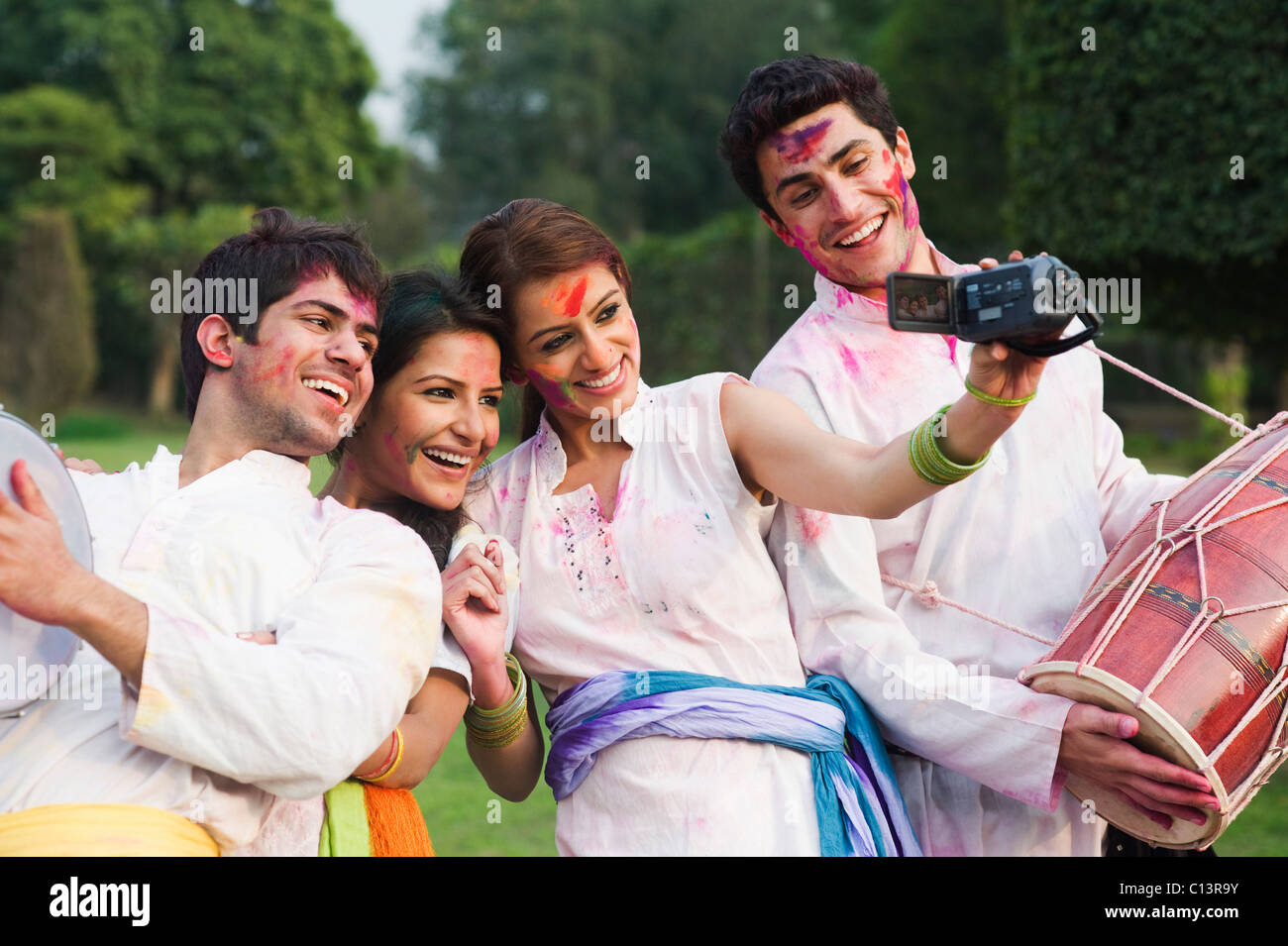 Friends taking a picture of themselves with a camera on Holi Stock Photo