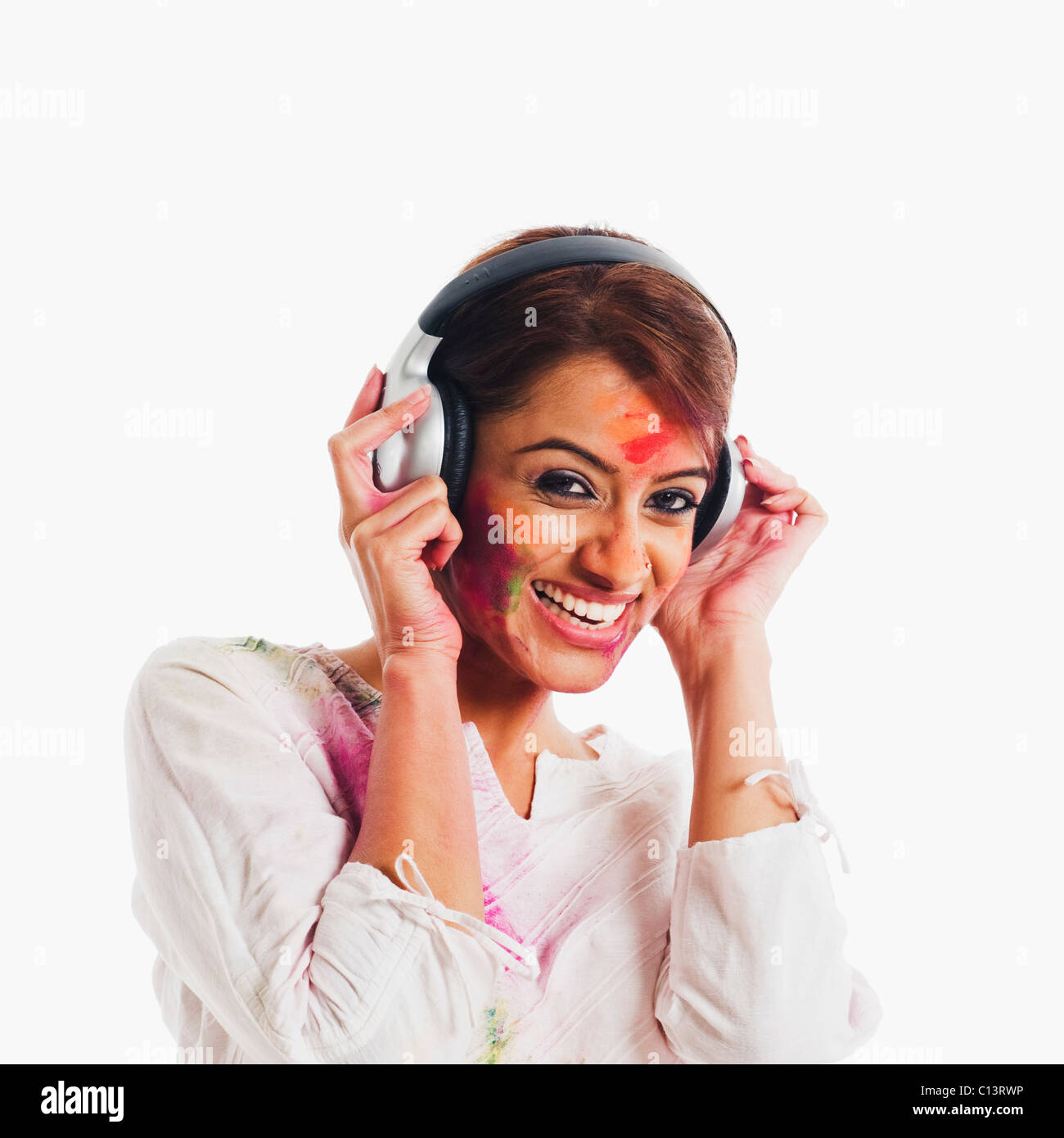 Woman listening to headphones on Holi Stock Photo