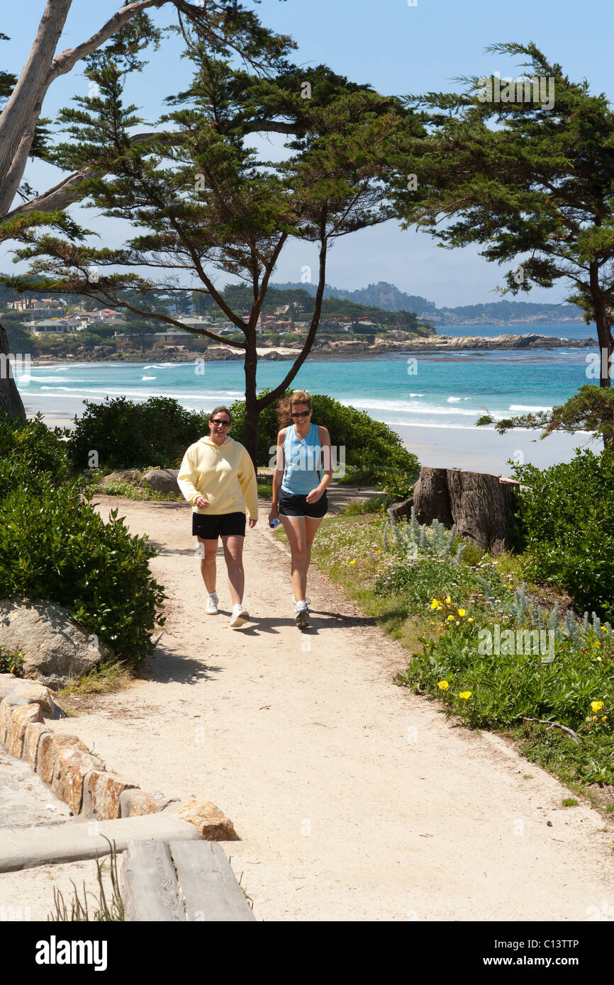 Shoreline, beach at Carmel, California. Two women walking on trail