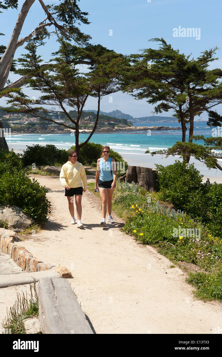 Shoreline, beach at Carmel, California. Two women walking on trail