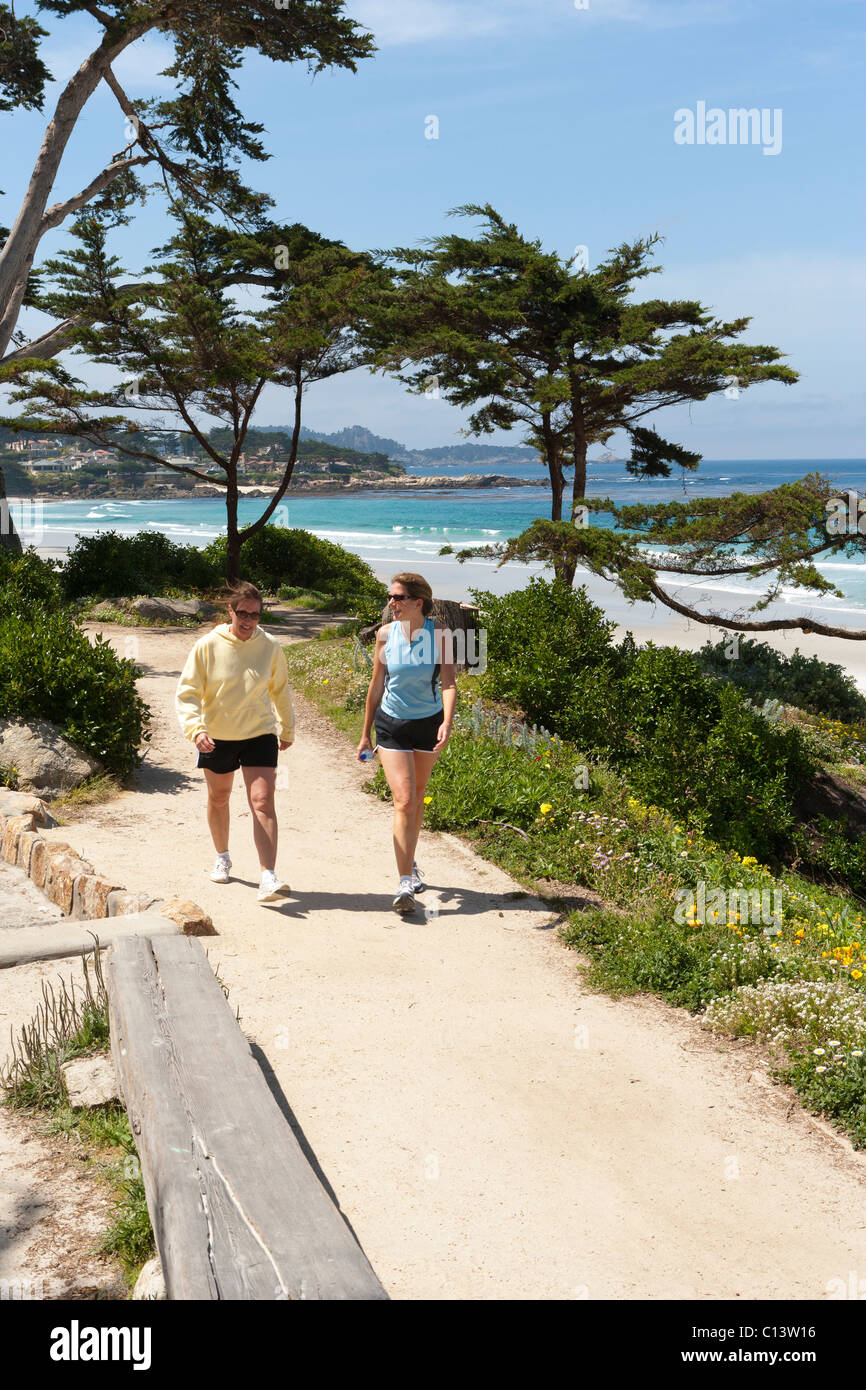 Shoreline, beach at Carmel, California. Two women walking on trail