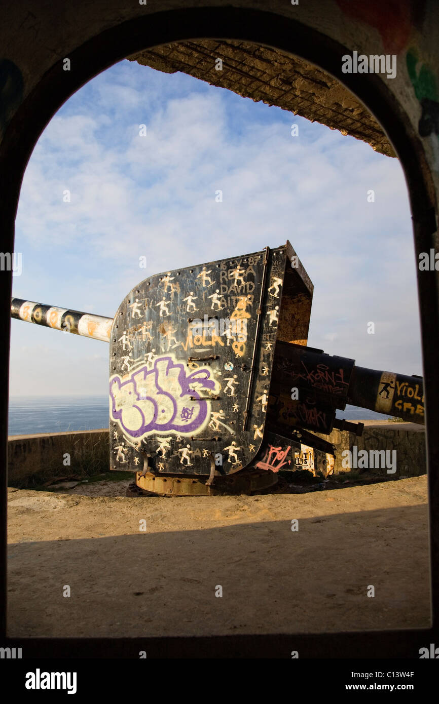 Old cannon battery with graffiti on the coastal Stock Photo