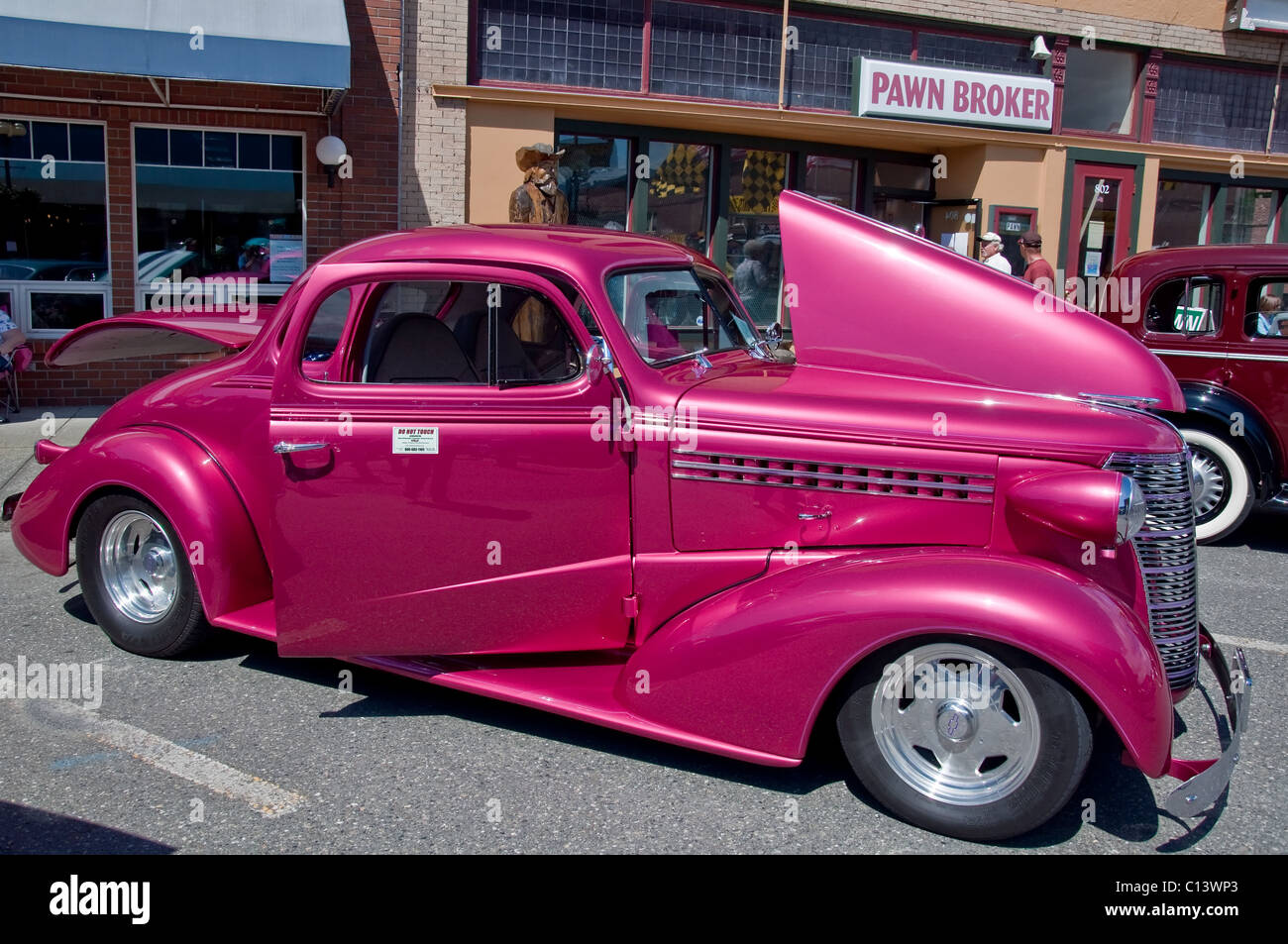 This restored vintage car a 1938 Chevrolet Coupe in a hot pink color was on display at a car show recently. Stock Photo