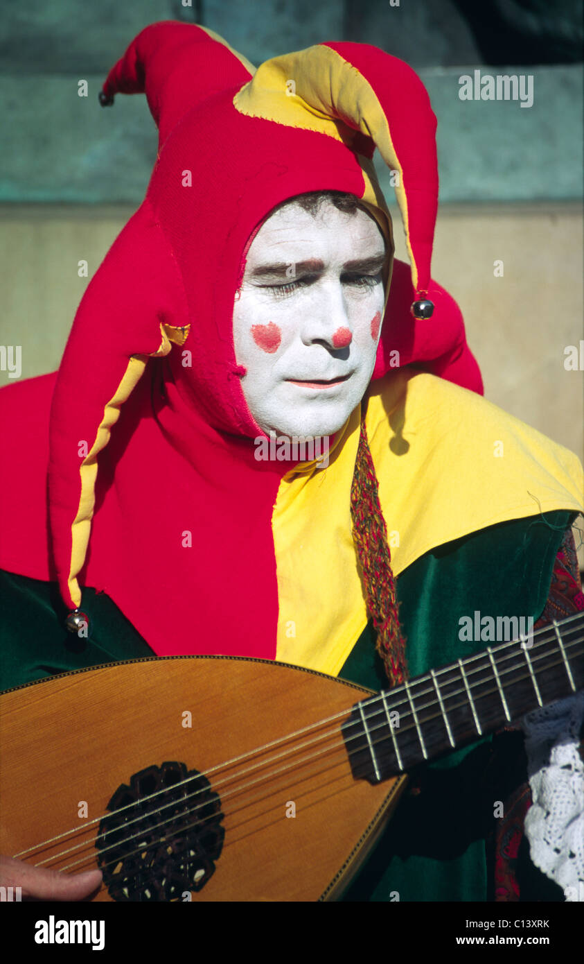 Busker dressed as a Joker and playing the lute during the Edinburgh Festival Fringe, Scotland, UK Stock Photo