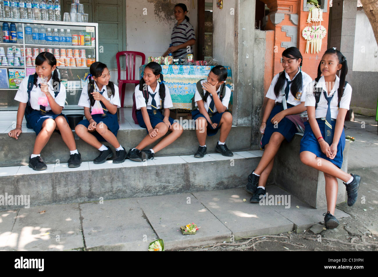 Balinese secondary school girls stop for a snack and a drink on their way home from school Stock Photo