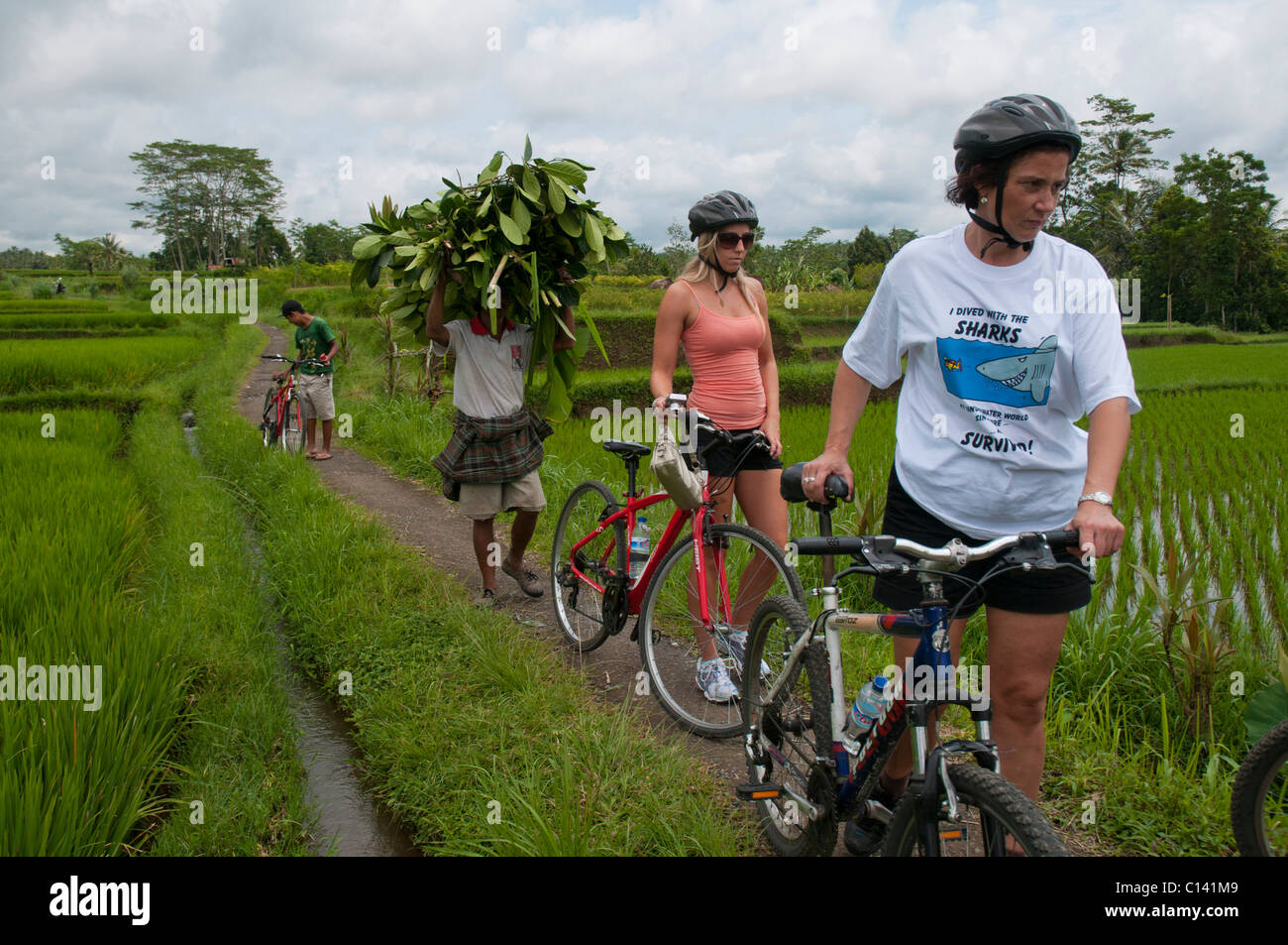 Mountain bike touring through villages and rice paddies in Bali Indonesia Stock Photo