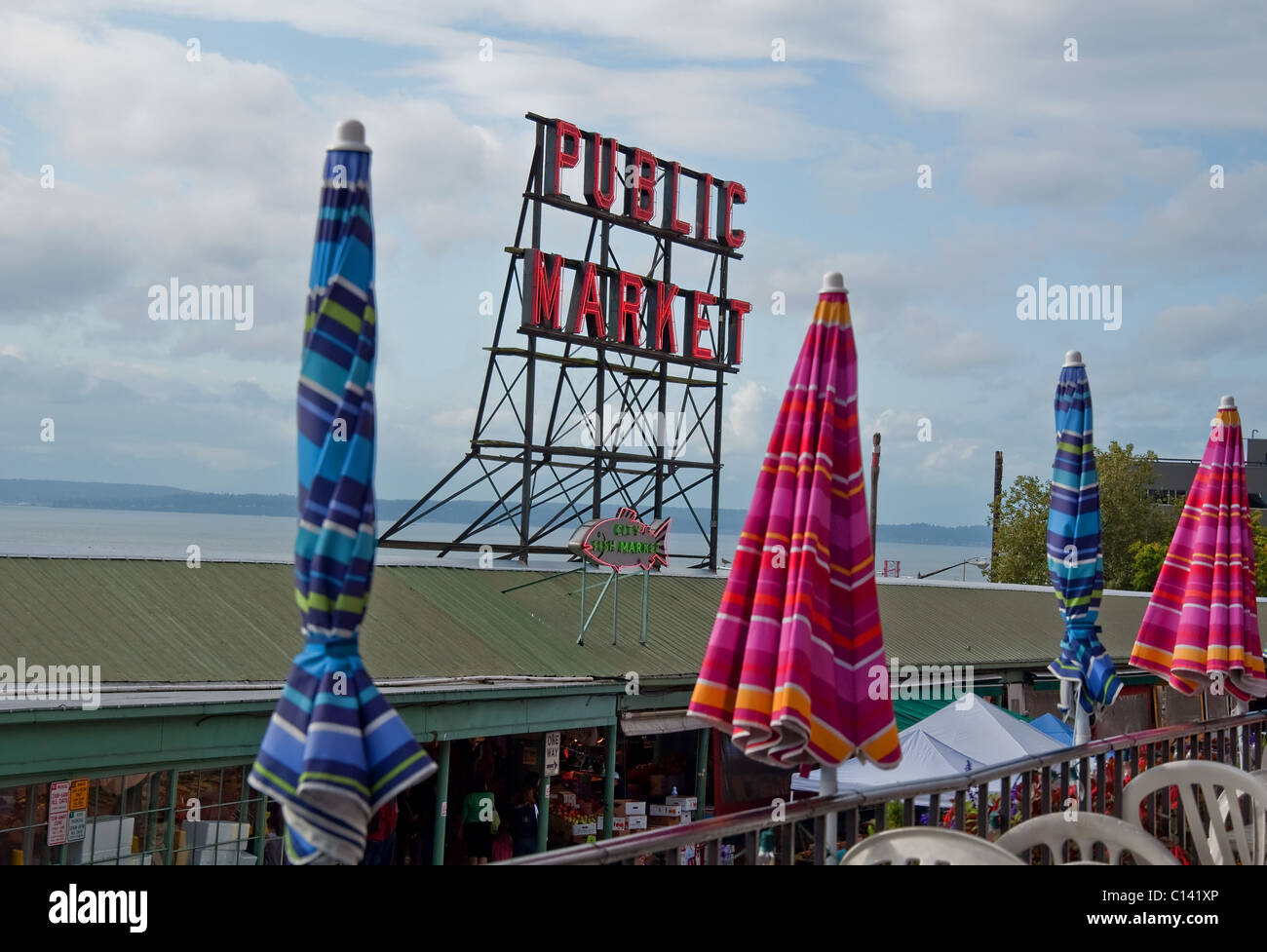 This horizontal stock image is the famous Pike Place Market, with the sign saying Public Market against a lightly cloudy day. Stock Photo