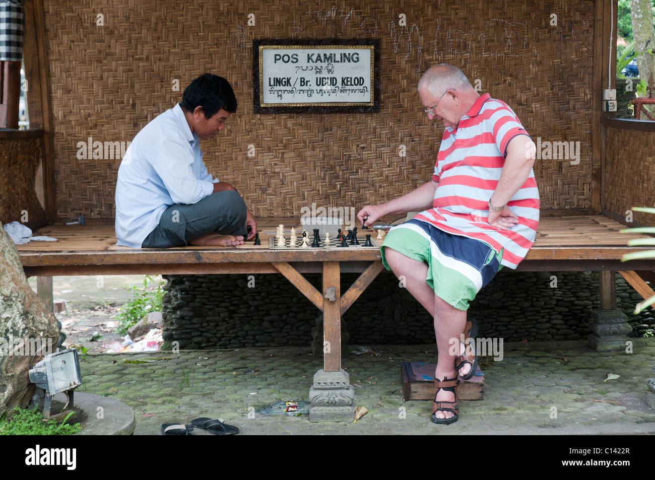 Elderly touriust playing a friendly game of chess with a local in Ubud, Bali, Indonesia Stock Photo