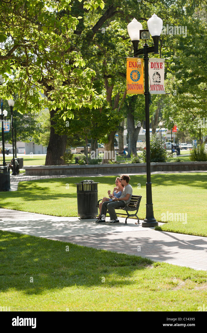 Couple sitting on park bench. City Park in downtown Paso Robles, California. Stock Photo