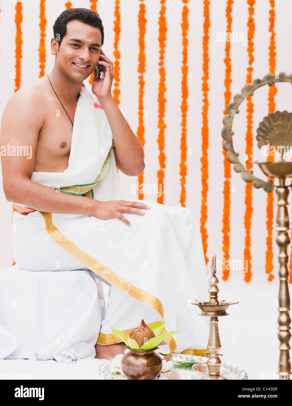Man talking on a mobile phone in traditional South Indian dress Stock Photo
