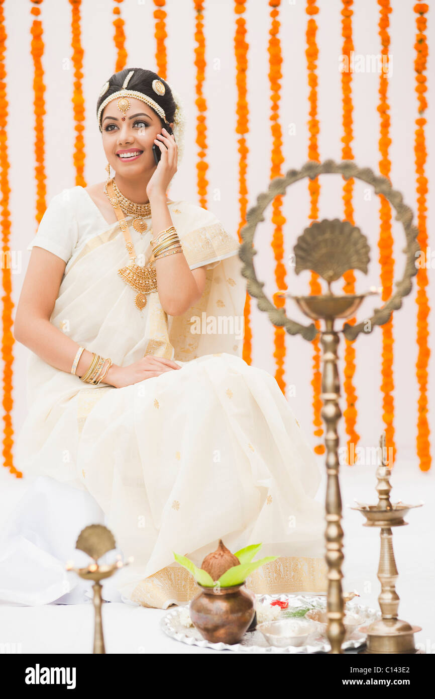 Bride in traditional South Indian dress talking on a mobile phone Stock Photo
