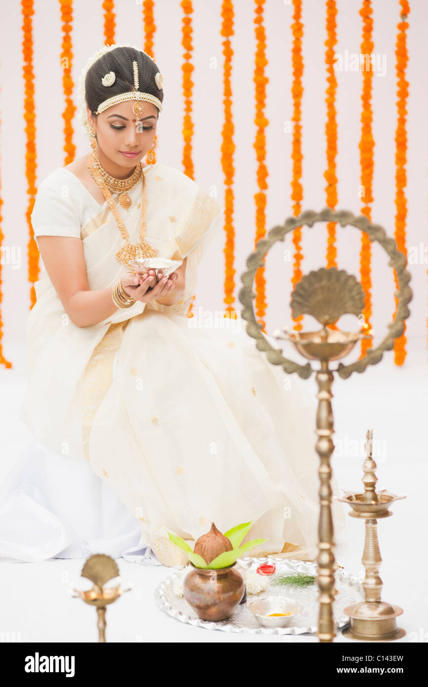 Bride in traditional South Indian dress praying with a oil lamp Stock Photo