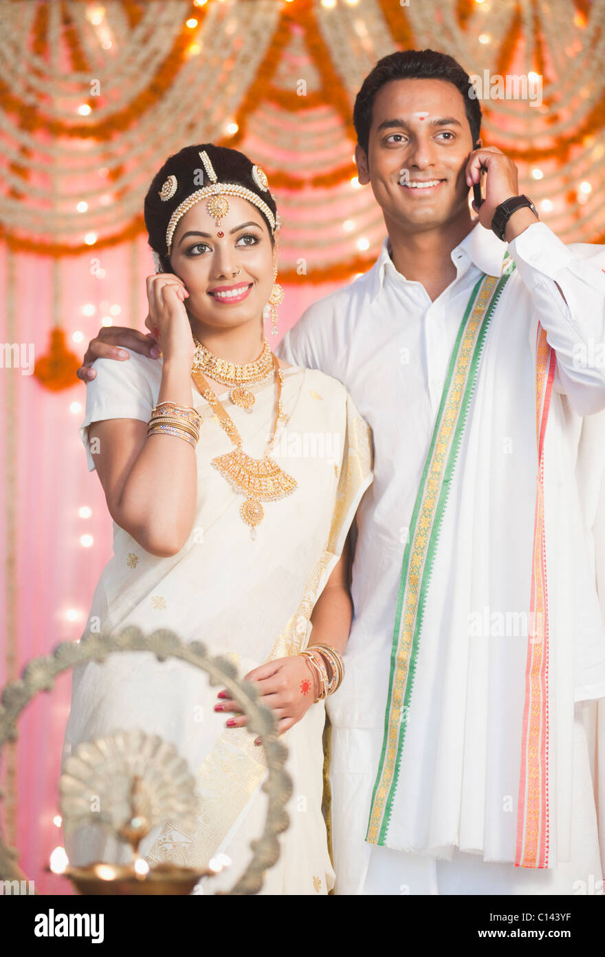 Bride and bridegroom in traditional South Indian dress talking on